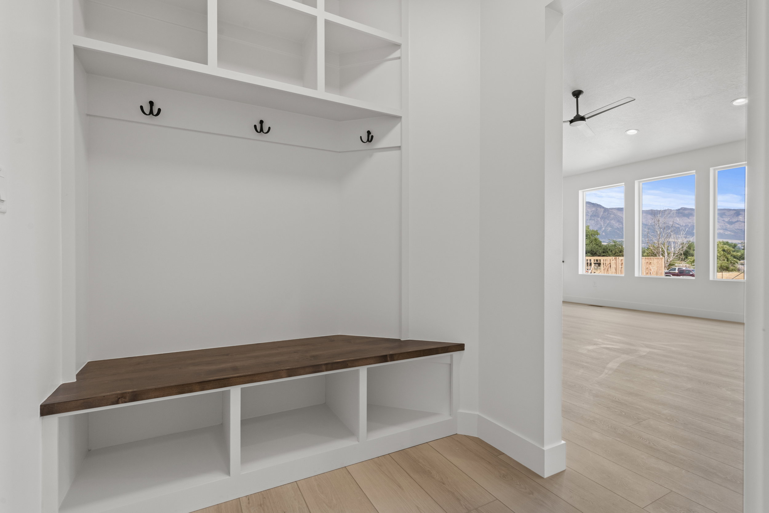 Built-in entryway storage with a wood-finish bench, integrated cubbies, and coat hooks