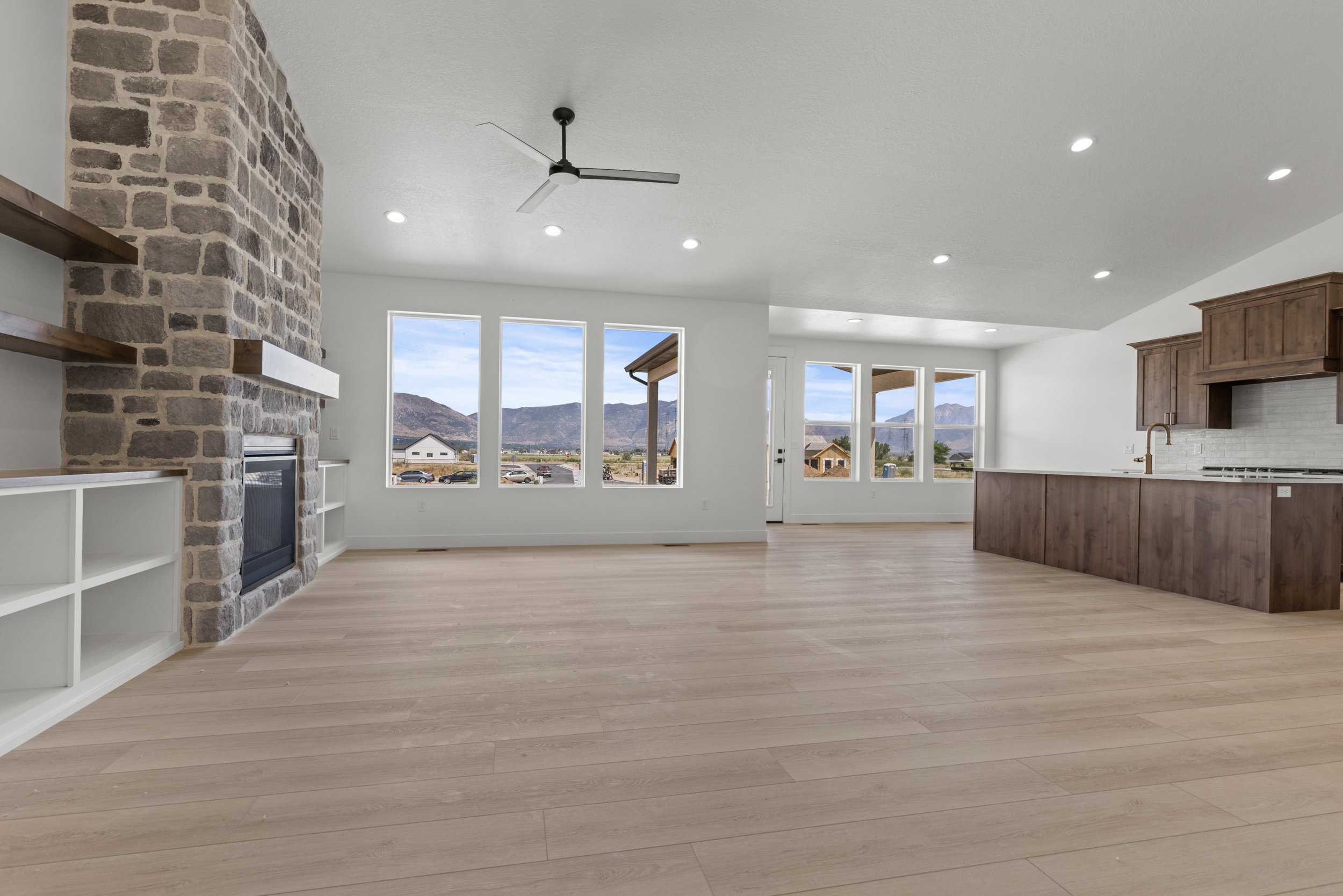Spacious open-concept interior featuring light wood-finish flooring and recessed lighting