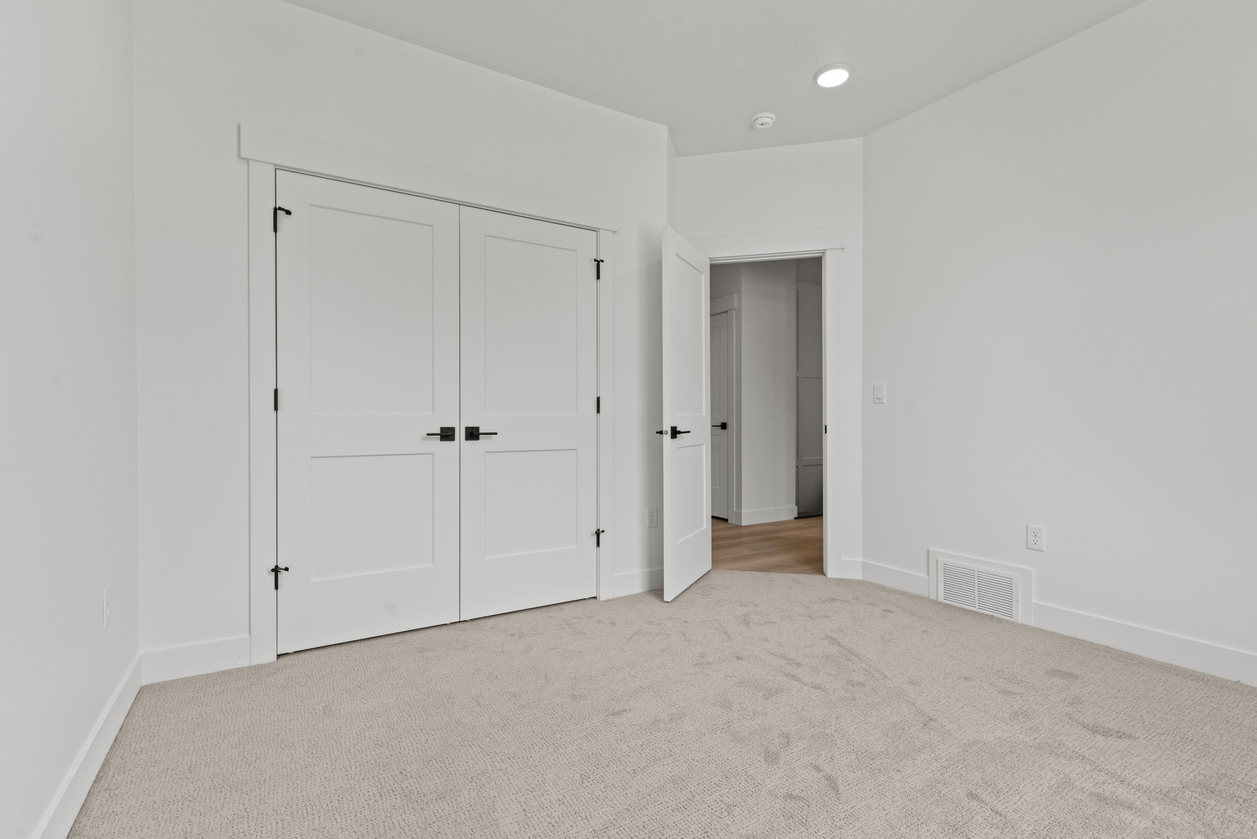 Neutral tone-on-tone carpet flooring extending to crisp white baseboards