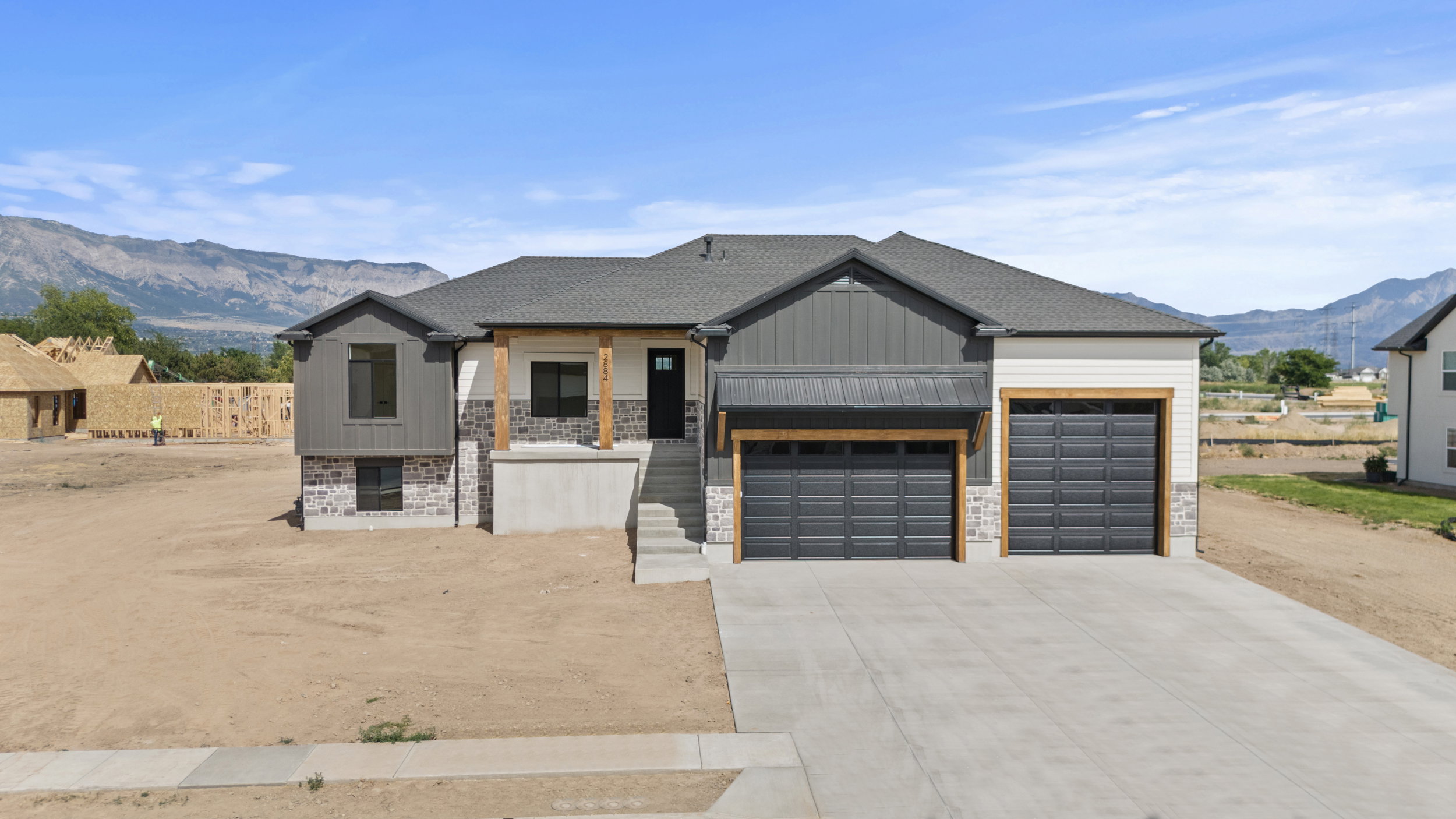 Contemporary exterior featuring a combination of horizontal siding, vertical panels, and stone accents