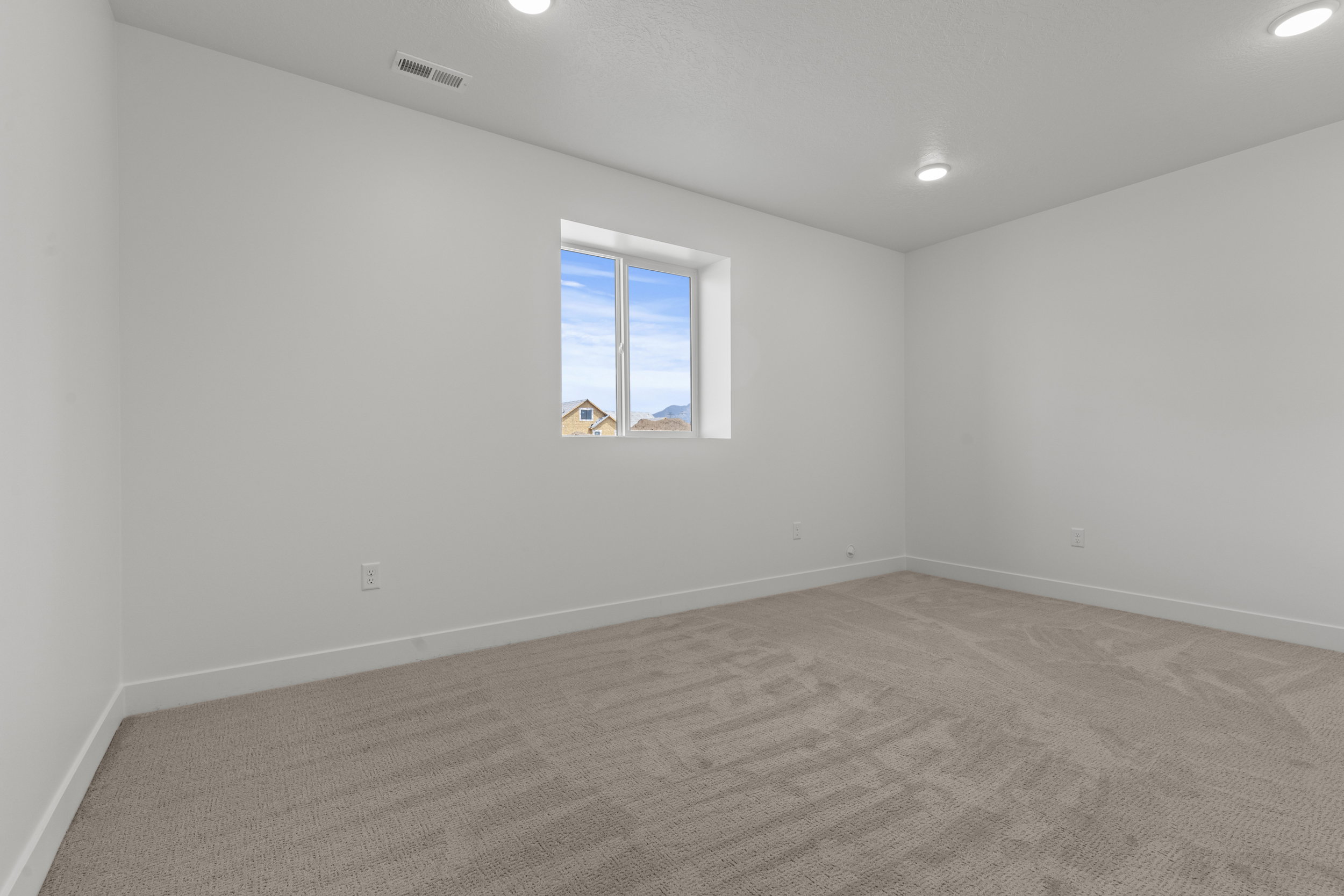 Carpeted room featuring a single window, white walls, white baseboards, and recessed ceiling lighting
