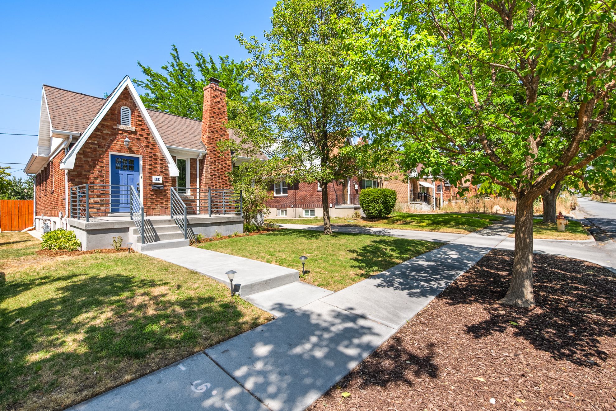 Brick exterior featuring a bright blue entry door and white trim accents