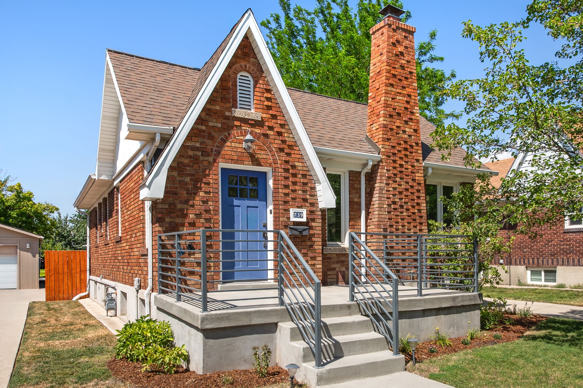 Brick exterior featuring a prominent front gable and a contrasting blue entry door