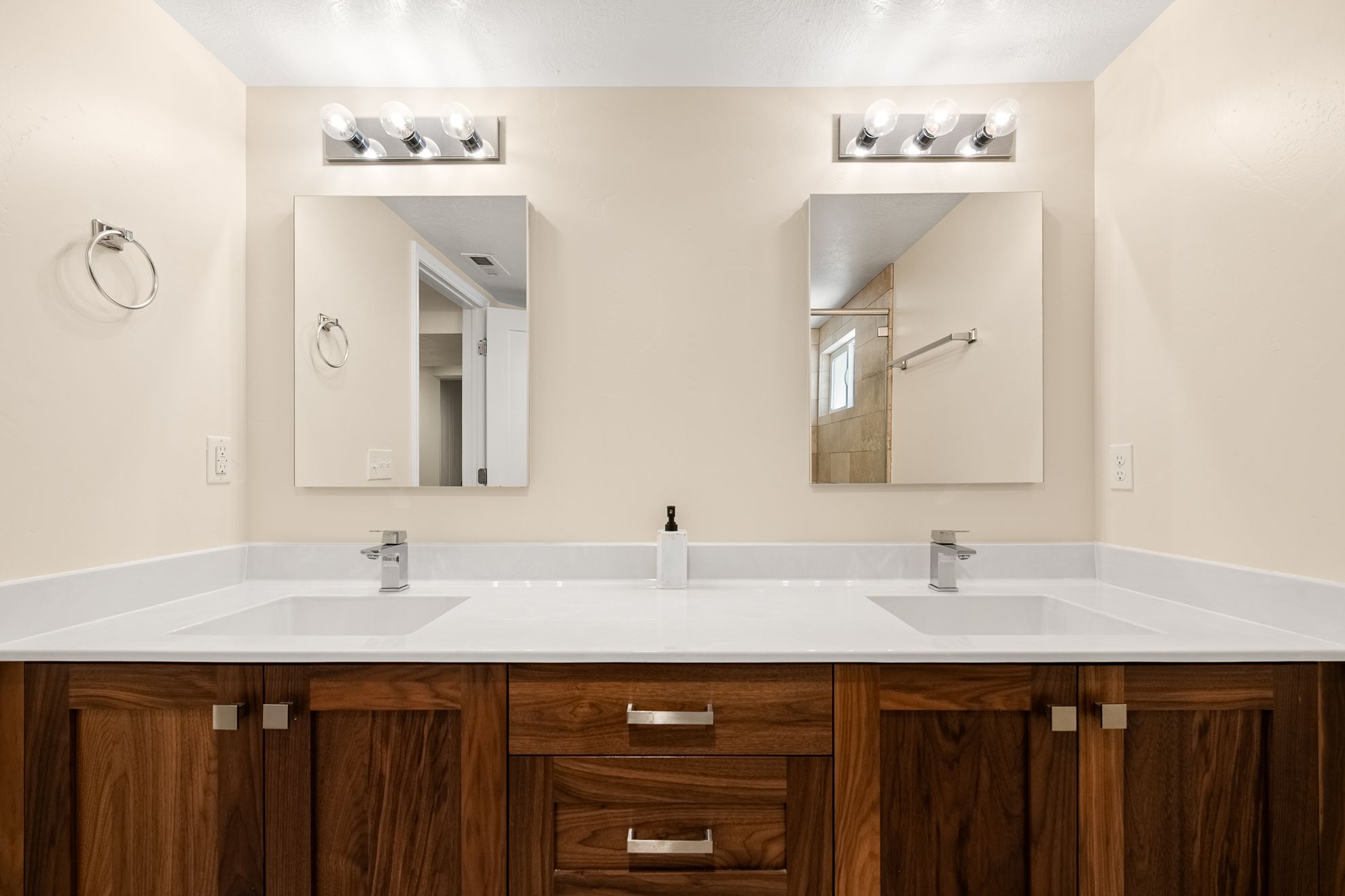 Double vanity featuring wood cabinetry, white countertops, and integrated sinks
