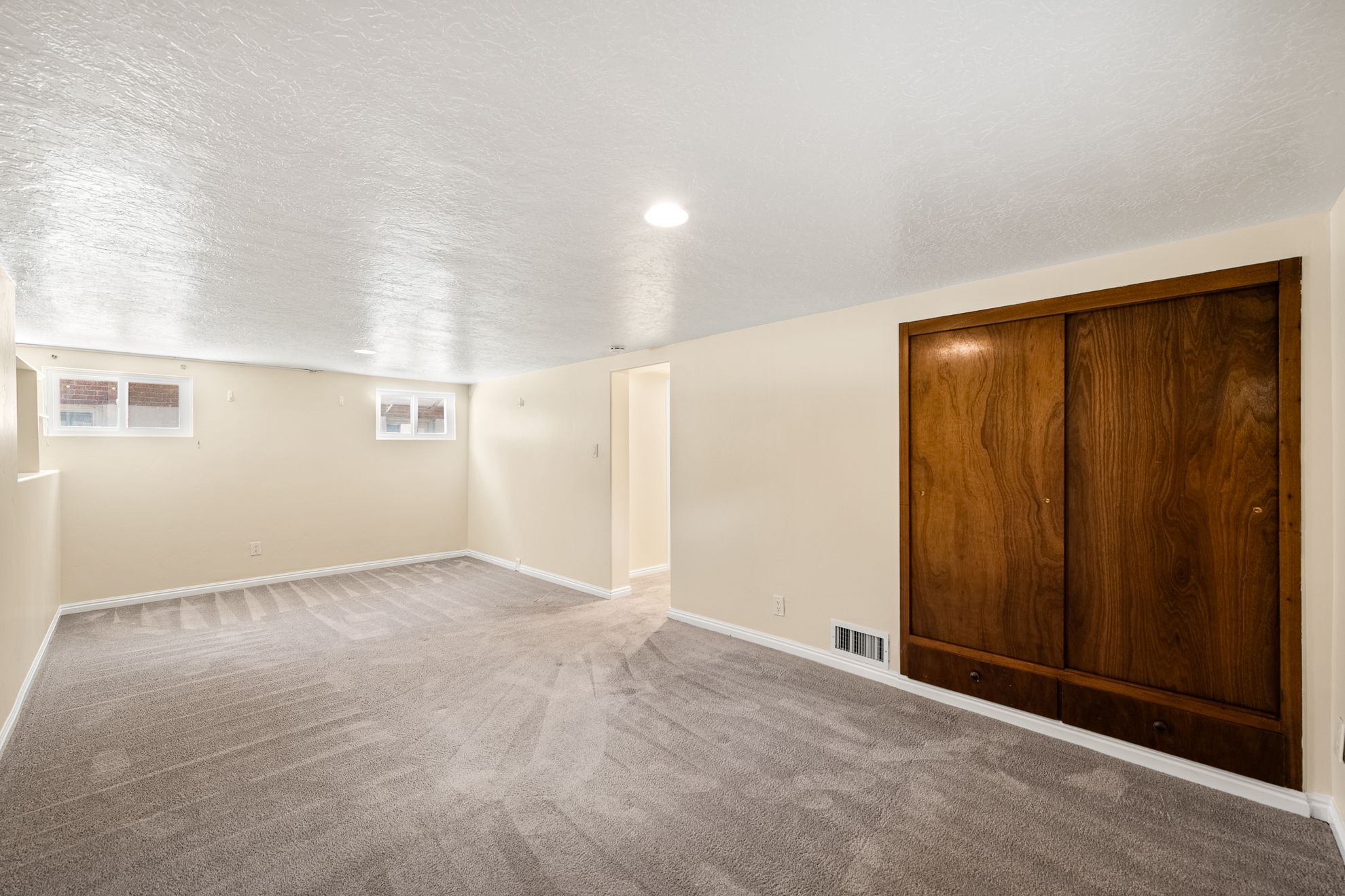 Spacious room featuring neutral carpeting and light-toned walls