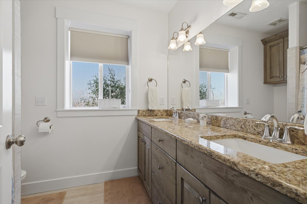 Dual vanity with a stone countertop and two integrated sinks