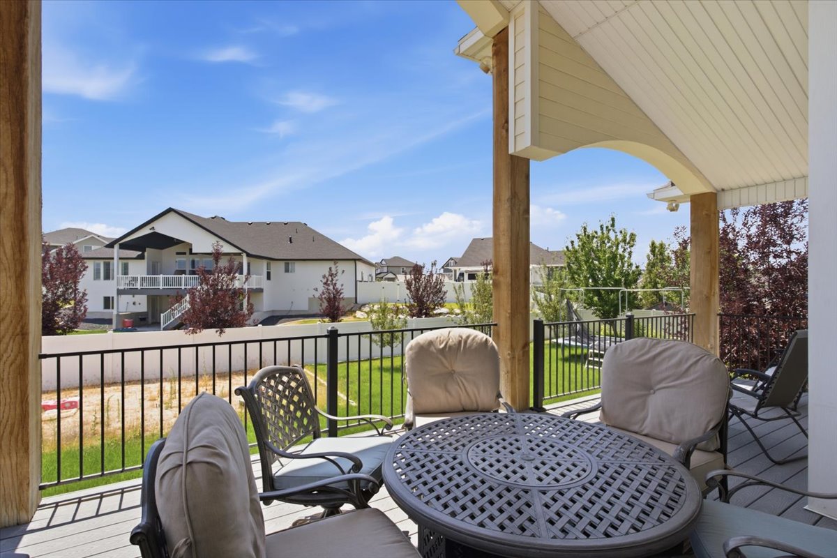 Covered outdoor deck with light wood-finish support beams and a textured gray deck surface