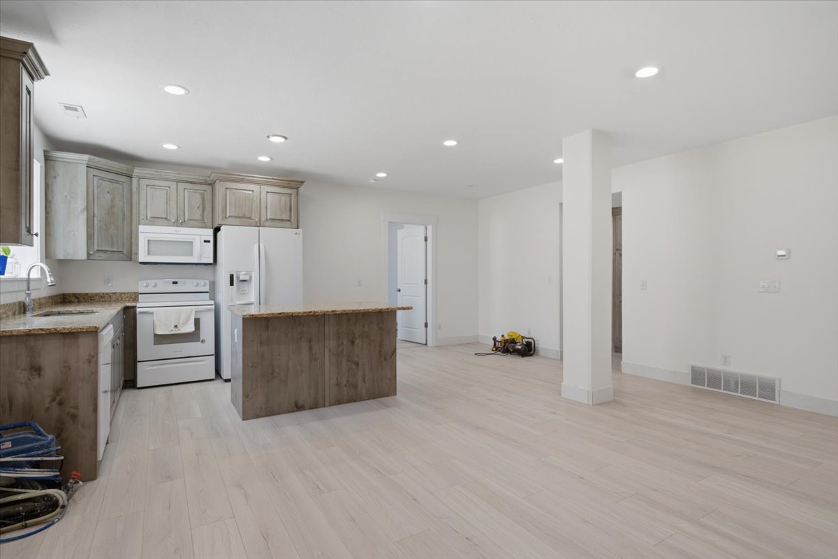 Open-concept kitchen and living area featuring light wood-finish flooring