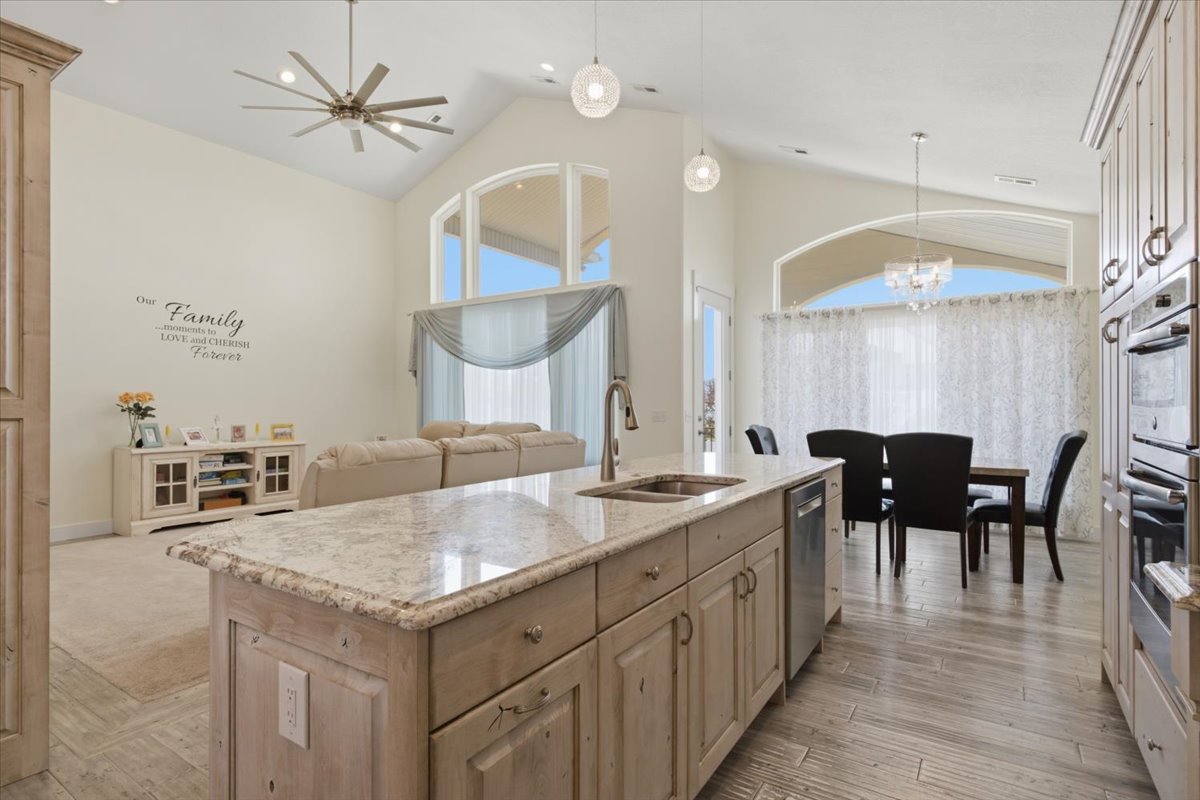 Kitchen island with an undermount sink and a light-toned countertop, complemented by light wood-finish cabinetry