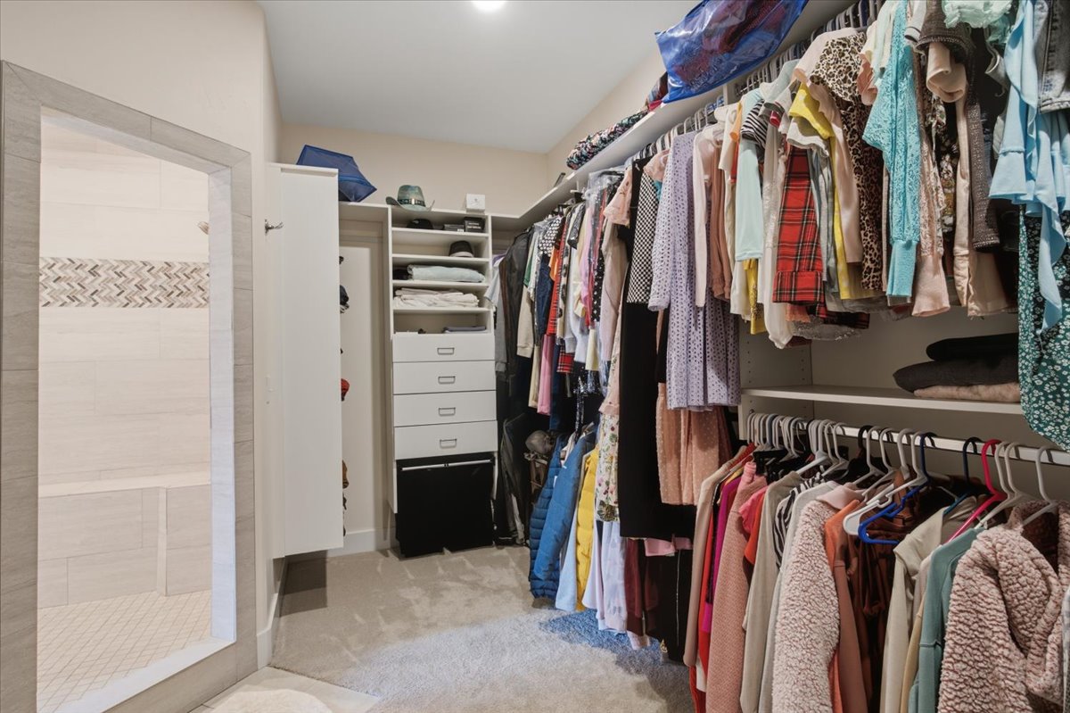 Walk-in closet with extensive custom shelving and built-in drawer storage