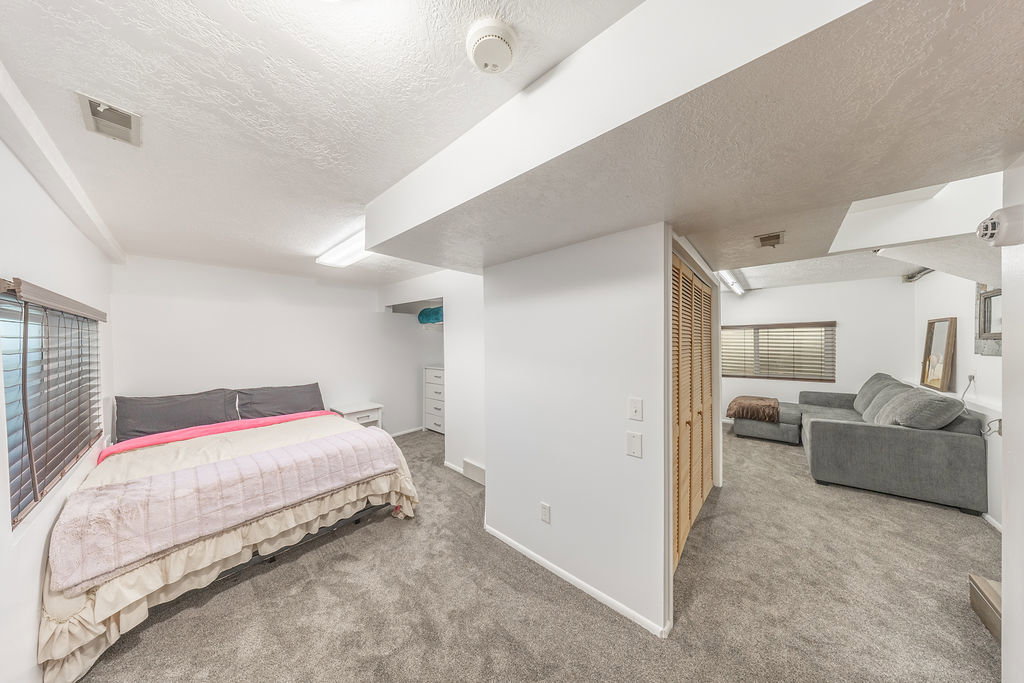 Carpeted room with a window featuring horizontal blinds
