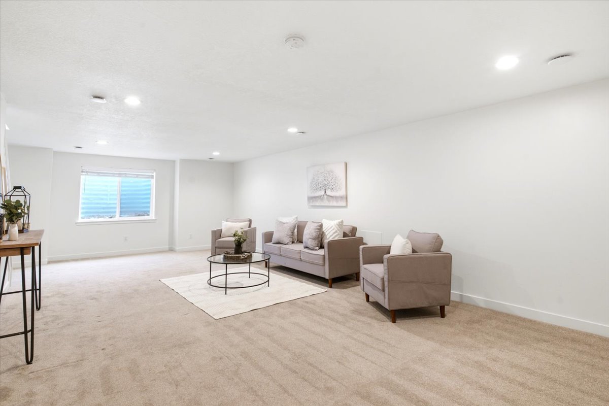 Spacious room featuring neutral carpeting, white wall finishes, and recessed ceiling lighting
