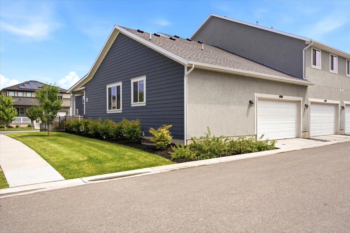 Exterior featuring blue horizontal siding, light stucco, and white trim