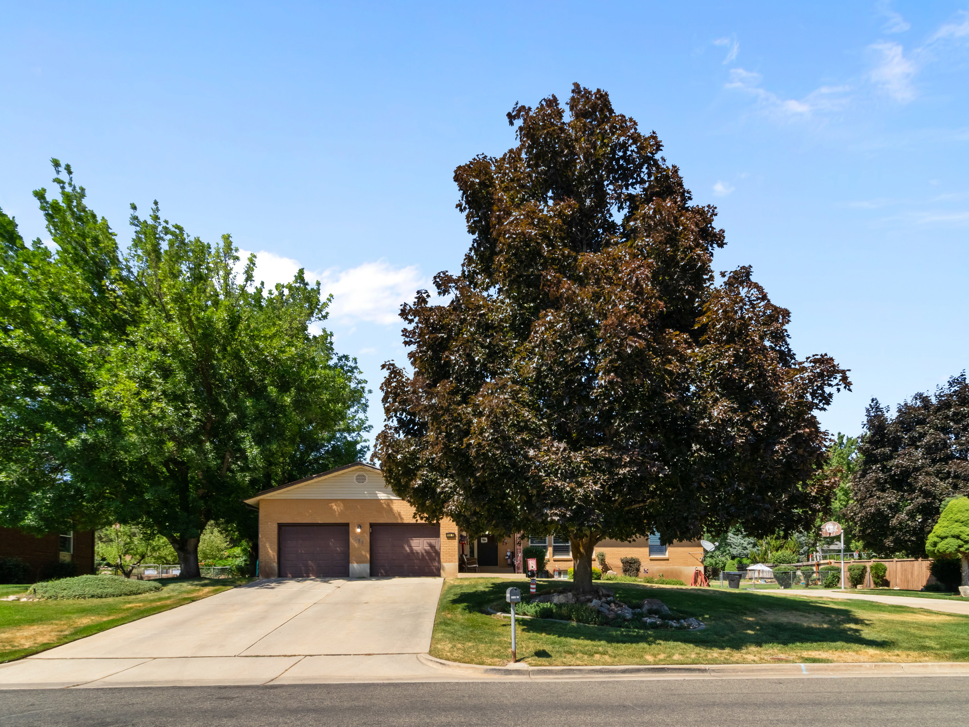 Single-story residence featuring a two-car garage with dark wood-finish doors