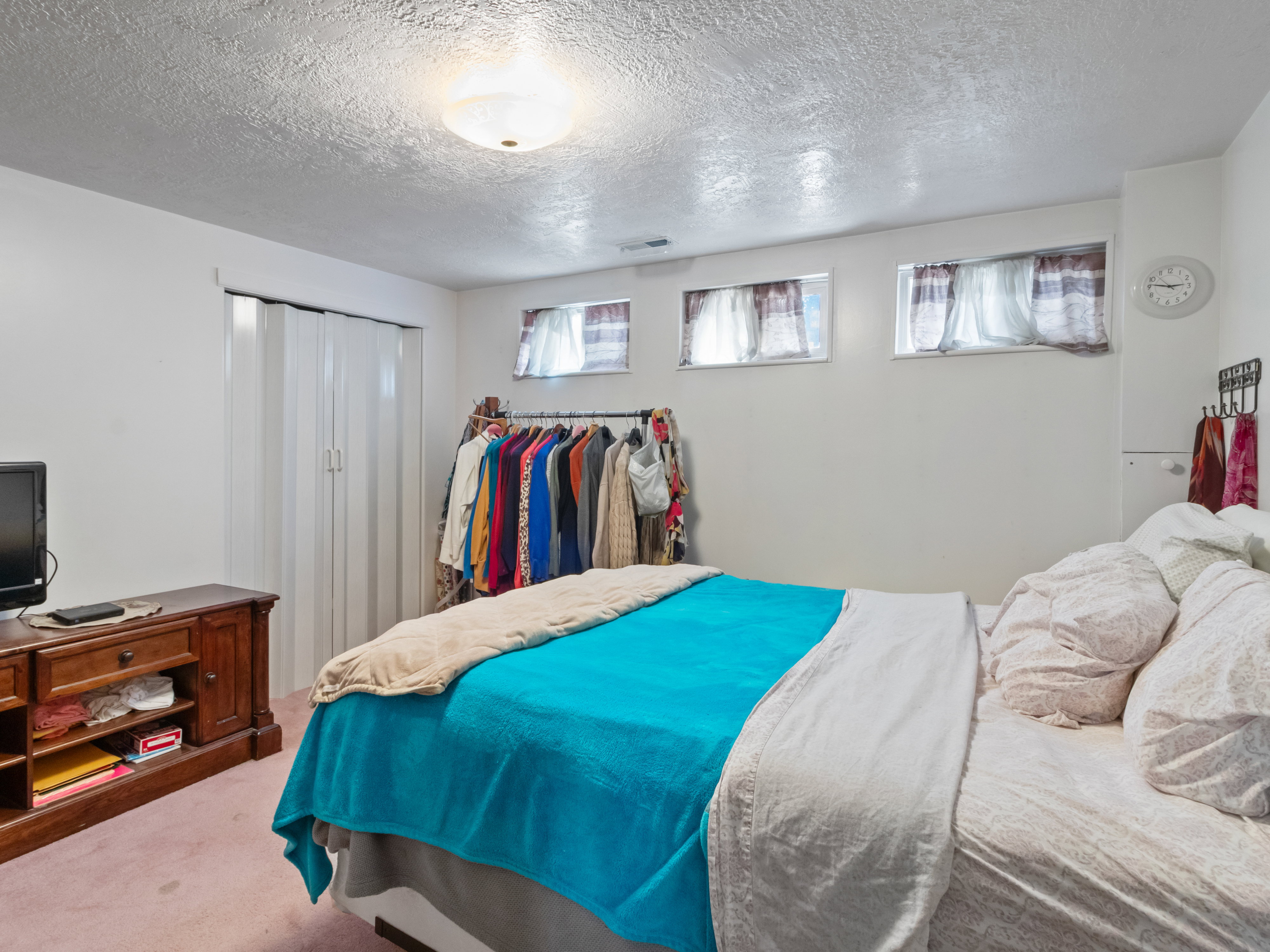 Bedroom featuring two small windows, a flush-mount ceiling light, and wall-to-wall carpeting