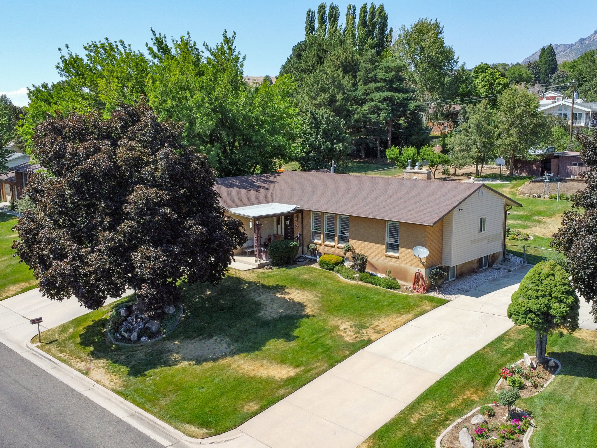 Ranch-style residence featuring a brick facade, covered front entry, and a brown shingle roof