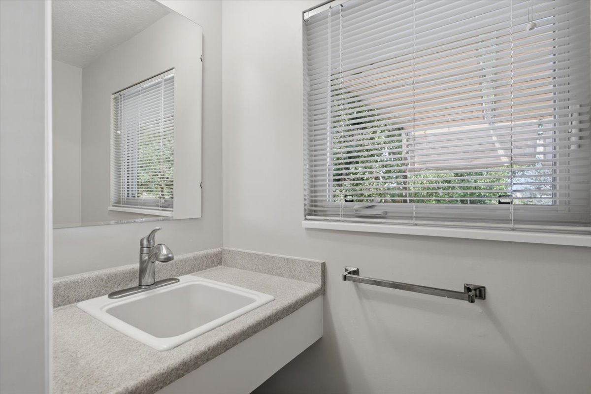 Bathroom vanity with an integrated sink, granite-look countertop, and a single-handle chrome faucet