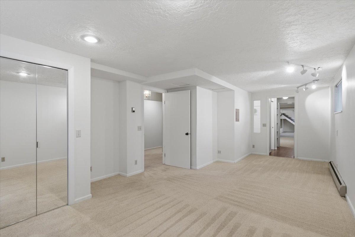 Spacious room featuring neutral carpeting and white walls