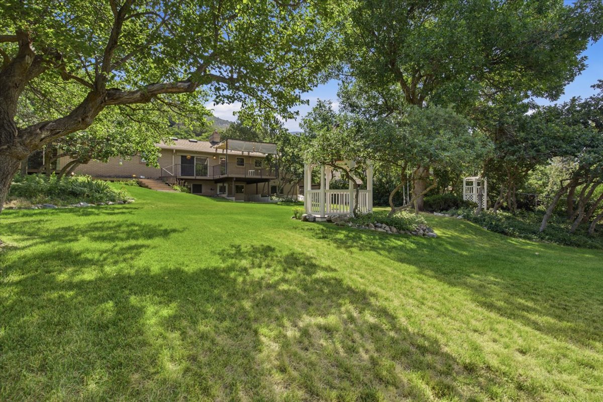 Expansive tiered lawn with mature trees and multiple white gazebos