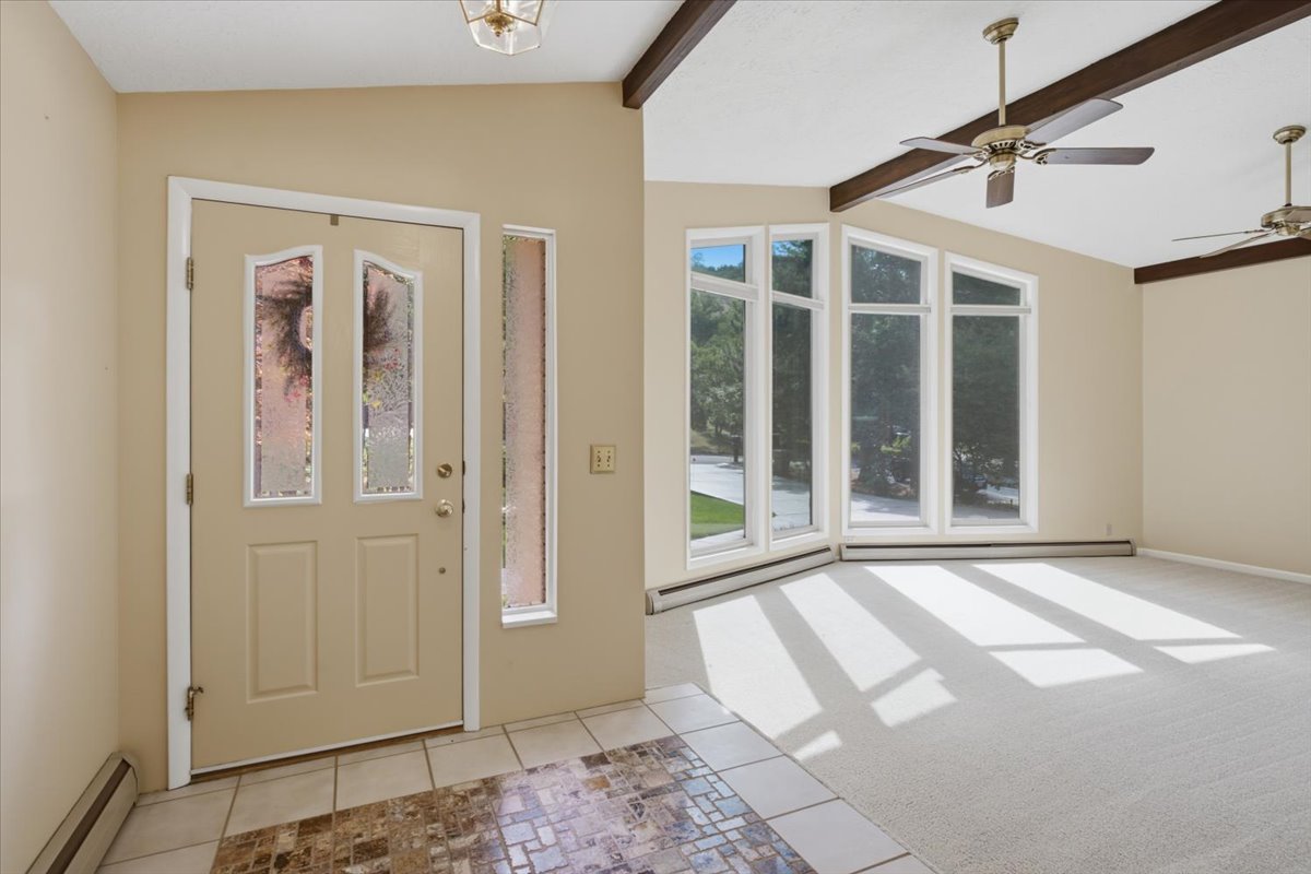 Entryway featuring a decorative glass-paneled door, side light window, and tiled flooring
