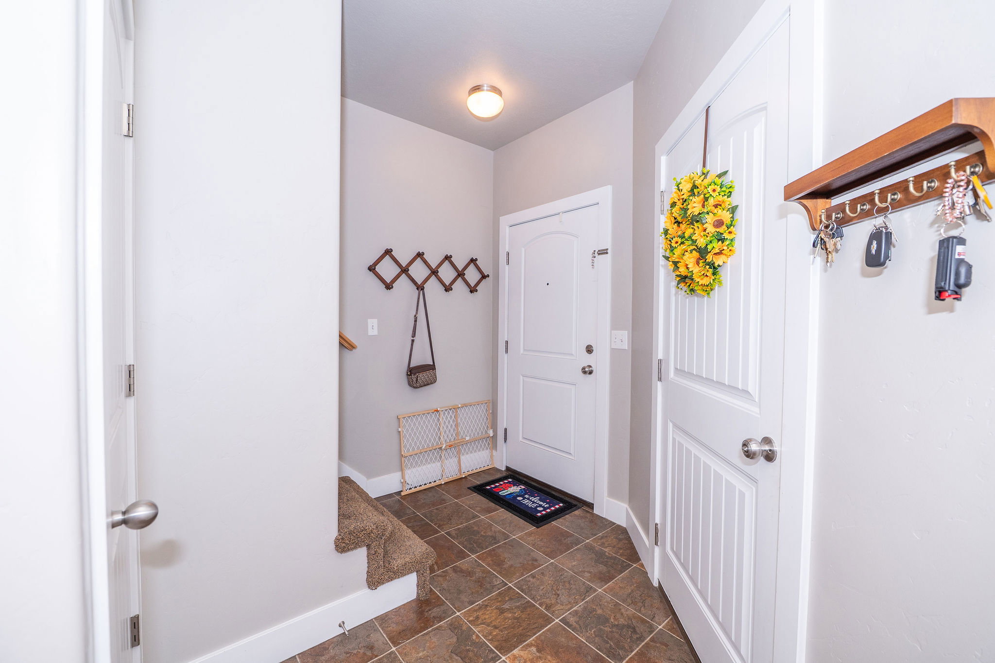 Entryway featuring brown tile flooring, white baseboards, and light gray walls