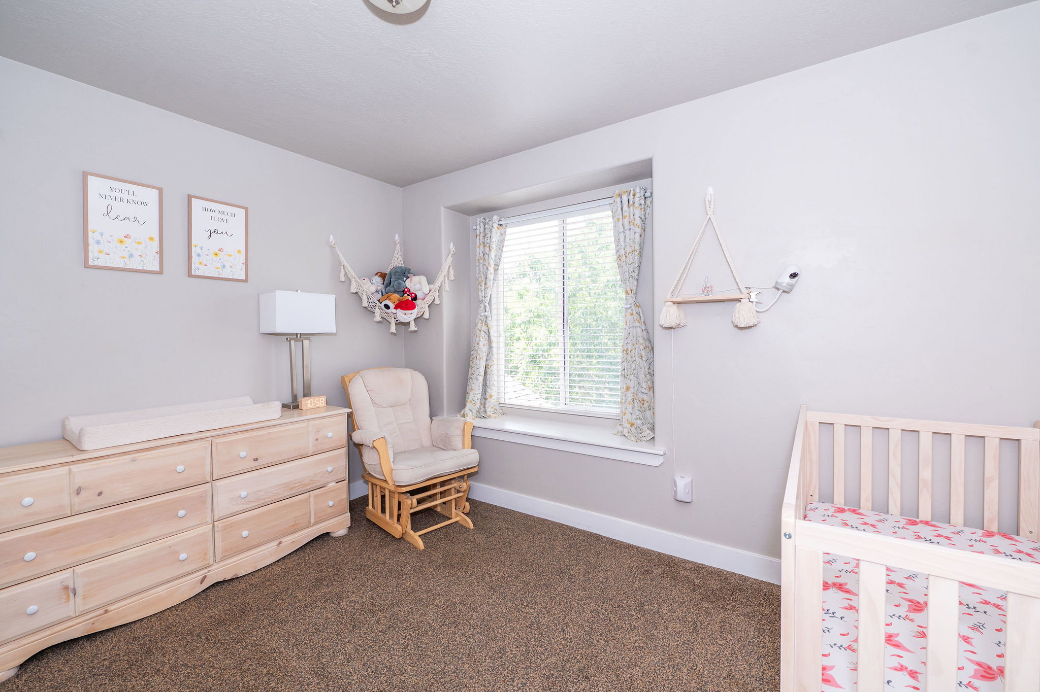 Bright room featuring a large window, neutral wall paint, and plush carpet flooring