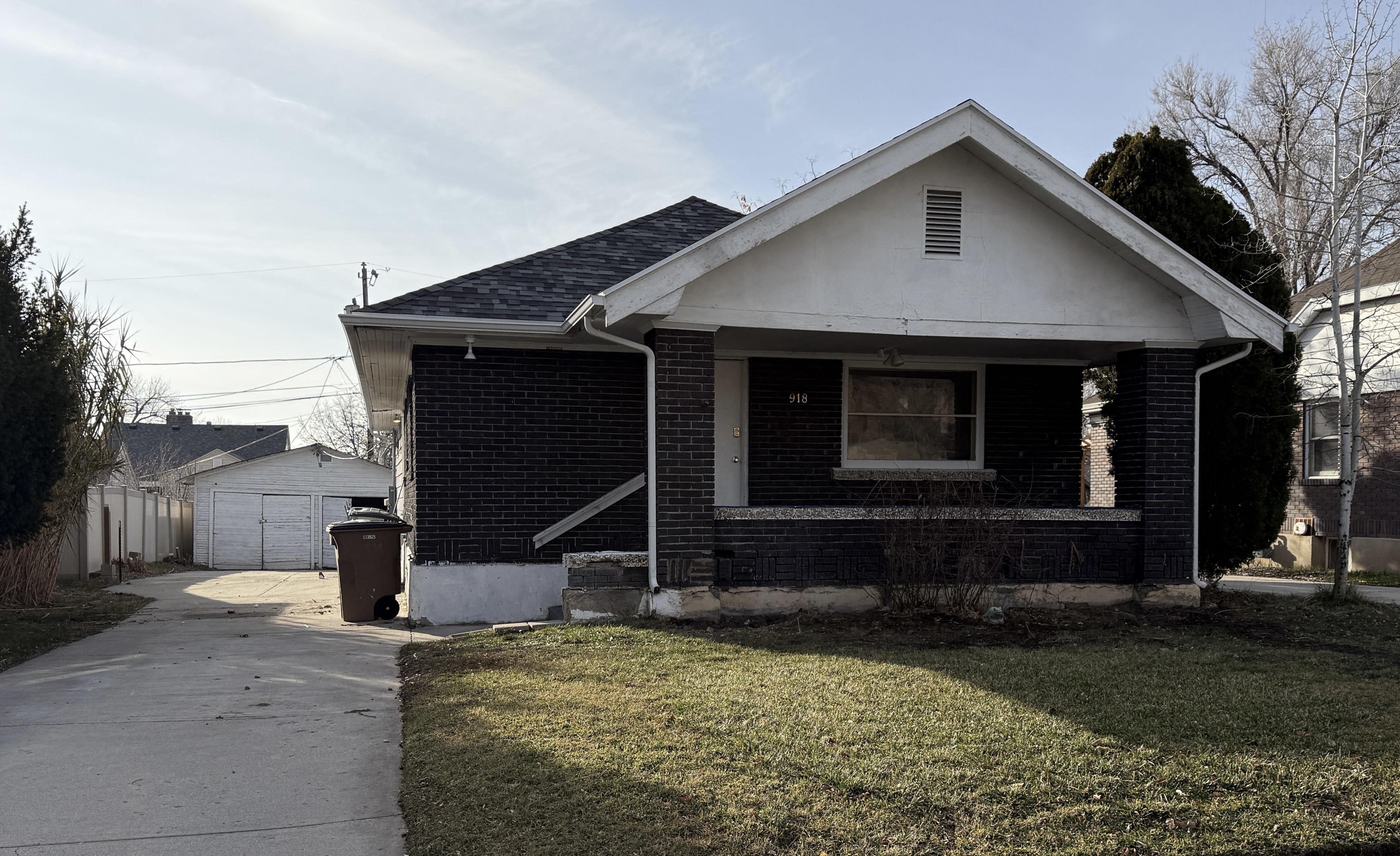Brick exterior with a covered porch, gabled roofline, and front lawn