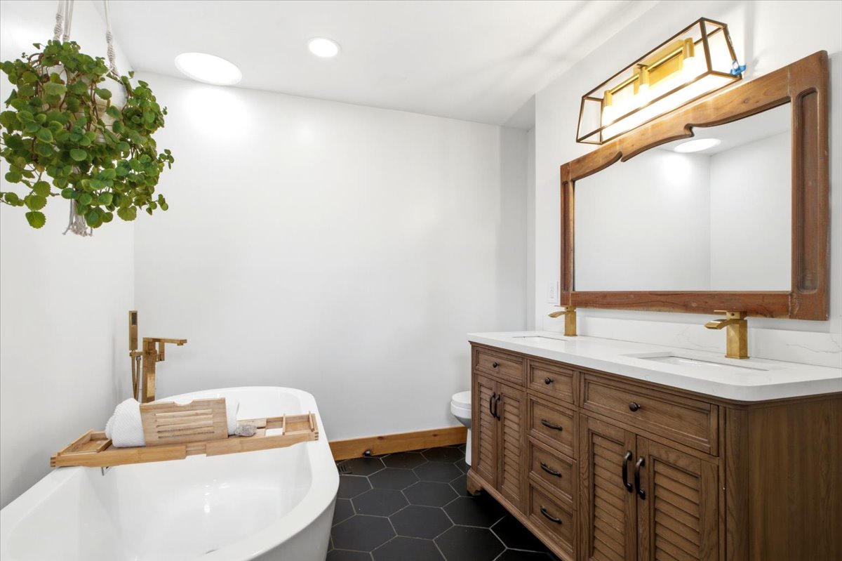 Freestanding soaking tub with floor-mounted brass faucet