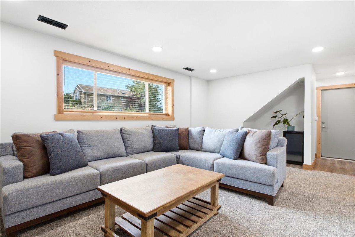 Carpeted living space with recessed lighting and a wood-trimmed window
