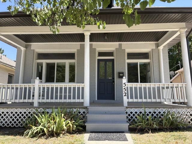 Inviting front porch featuring classic white railing and columns
