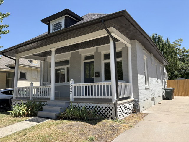 Two-story residence featuring a covered front porch with white columns and railing