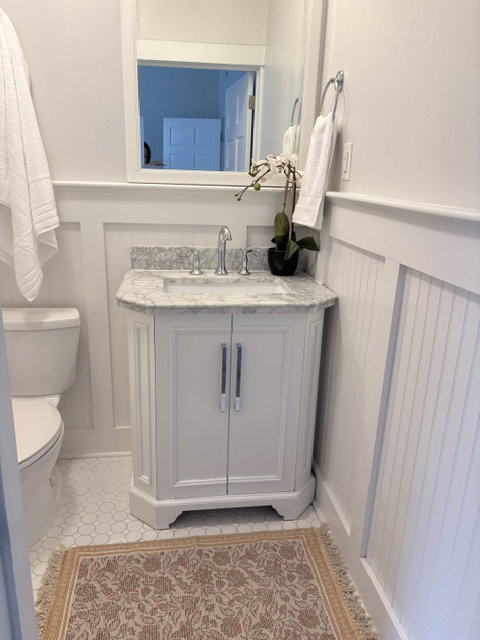 White vanity with a stone countertop and undermount sink