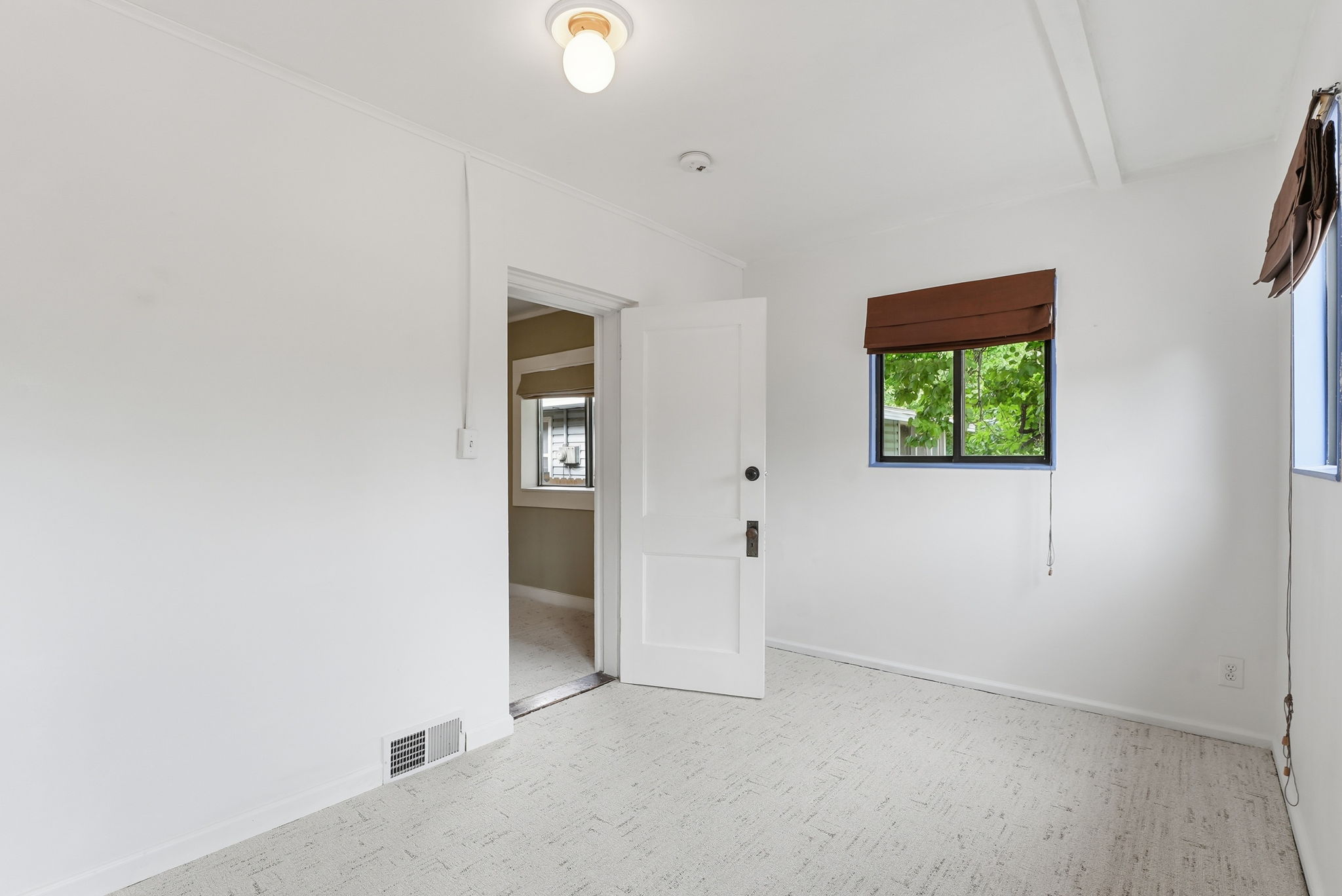Bright interior room featuring light-toned flooring and white painted walls