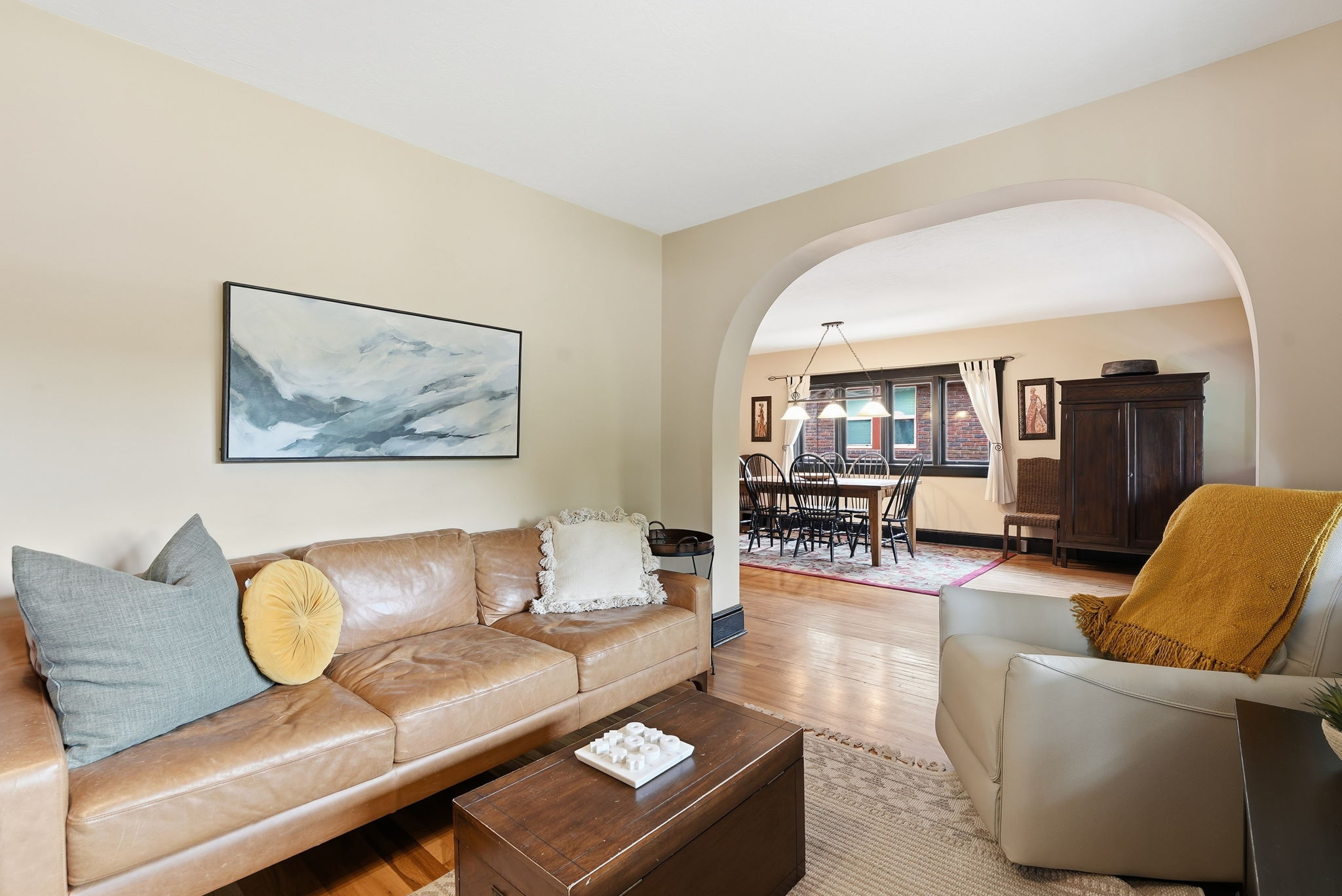 Living area featuring hardwood flooring, an arched doorway, and light-toned walls