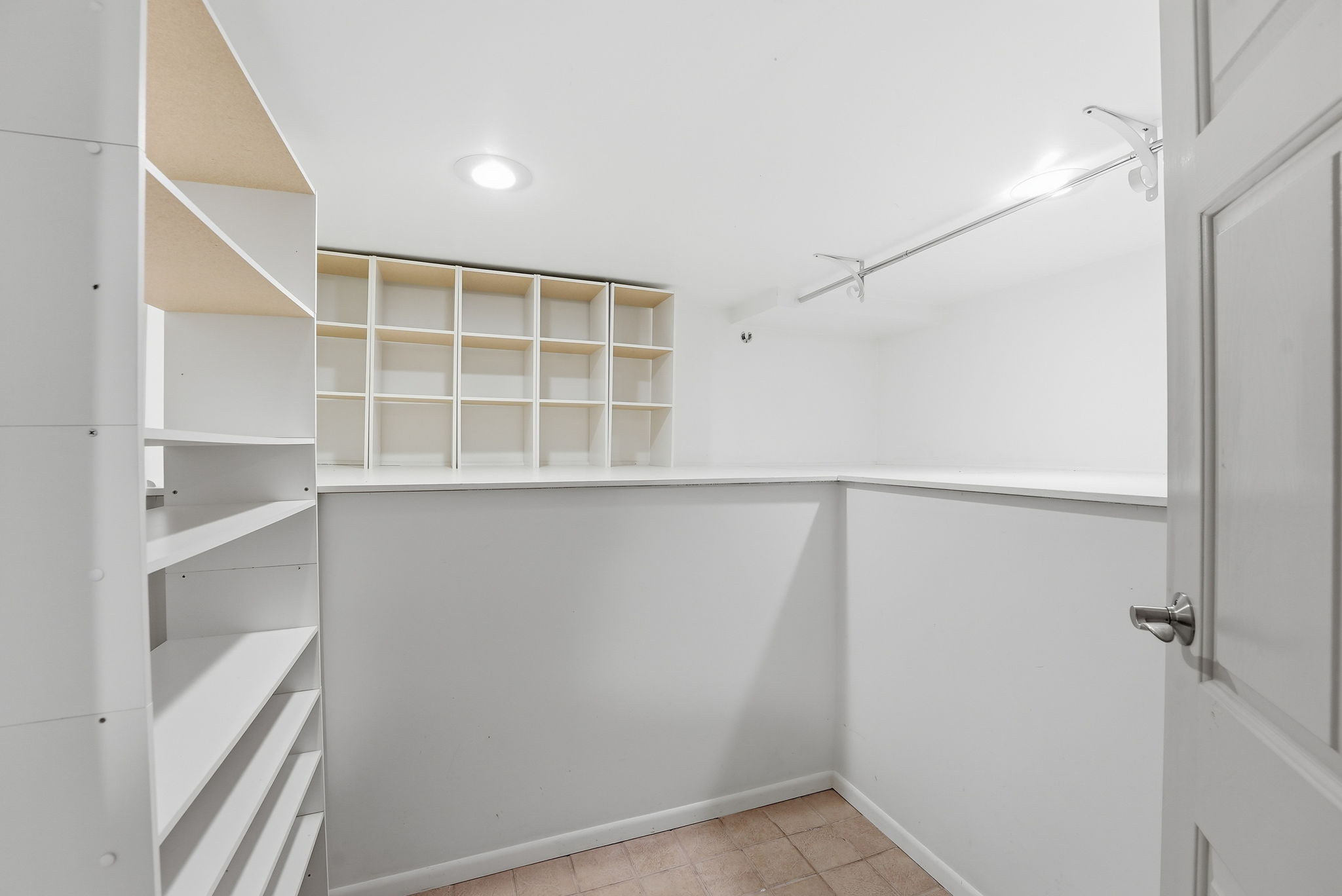 Walk-in closet featuring recessed lighting, a clothes rod, built-in shelving, and tile flooring