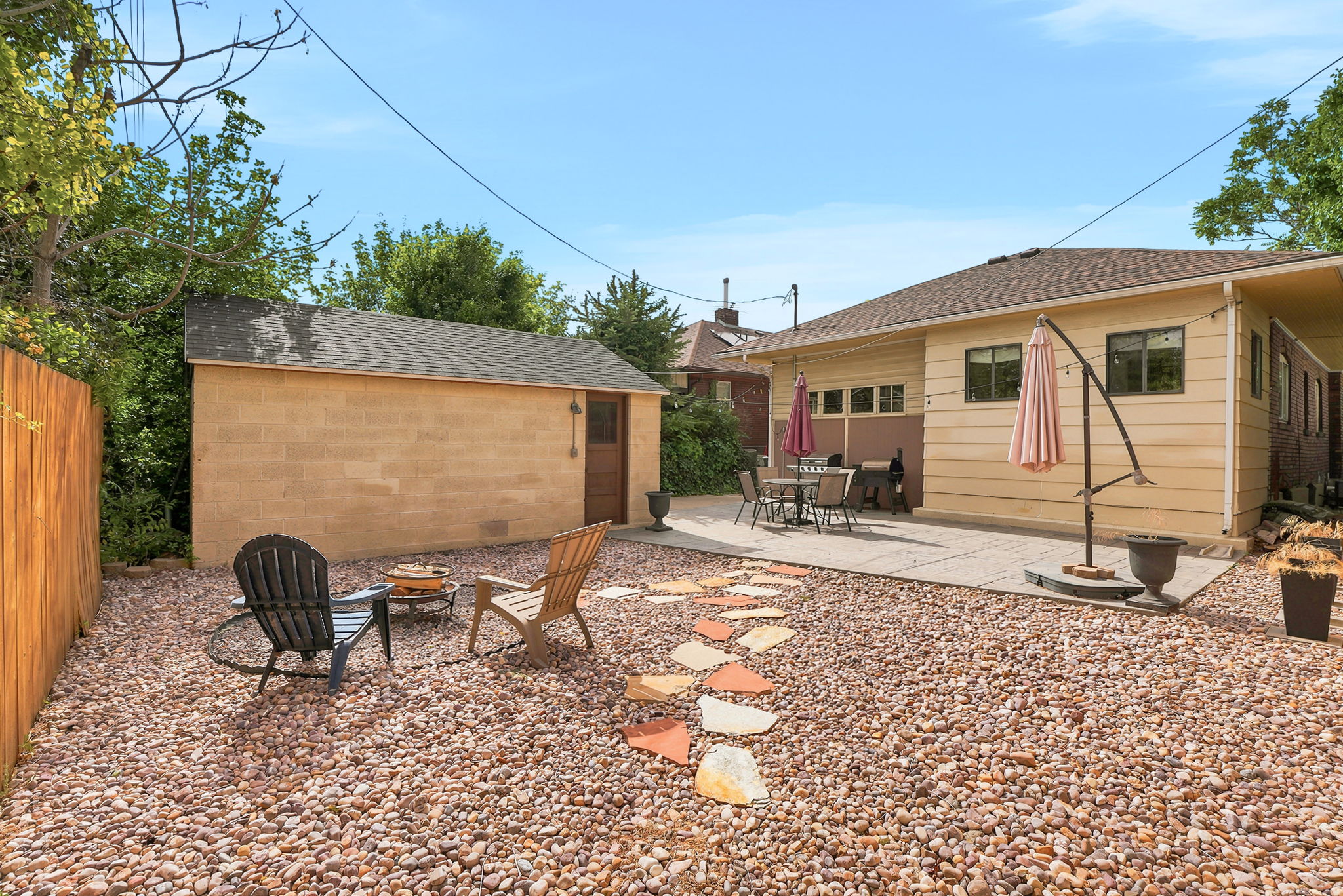 Expansive backyard featuring a gravel landscape and a stone paver patio