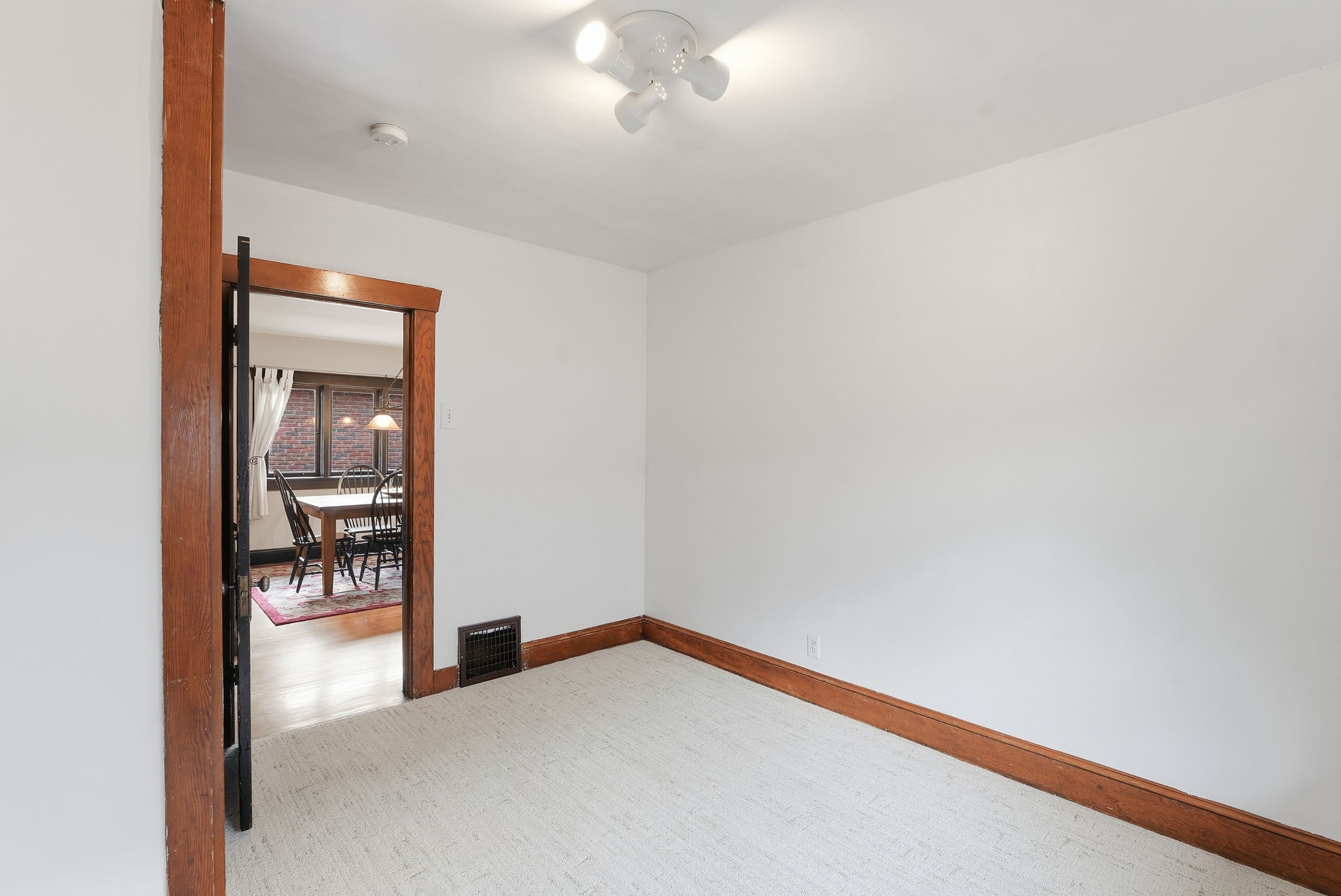 Bright interior room featuring light-toned carpet flooring and white painted walls