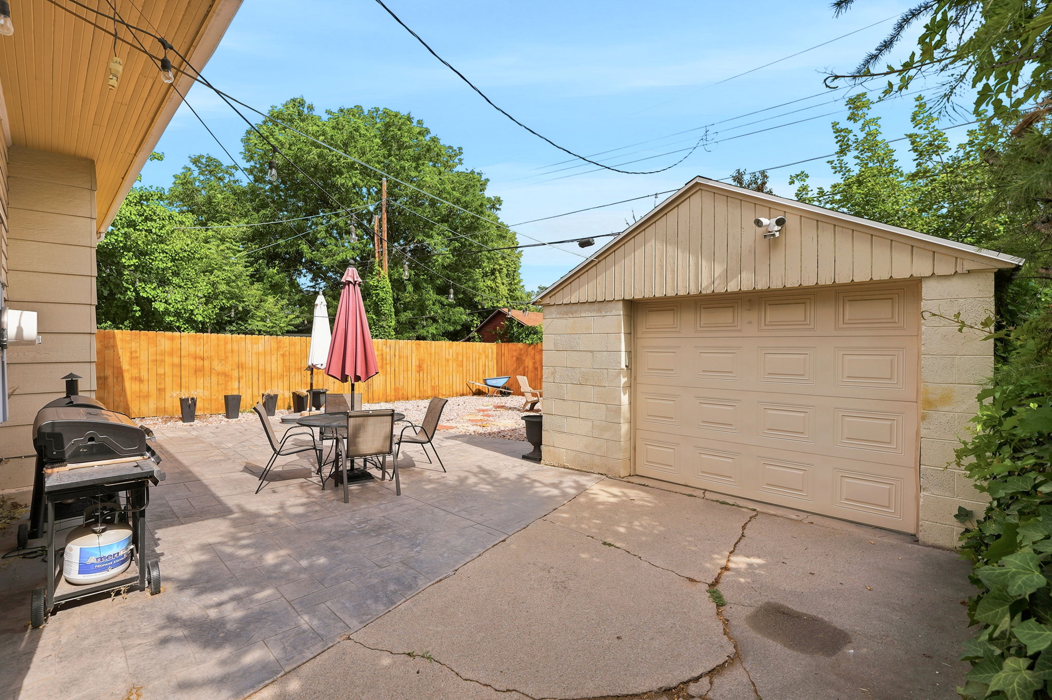 Expansive concrete patio with a privacy fence and detached garage