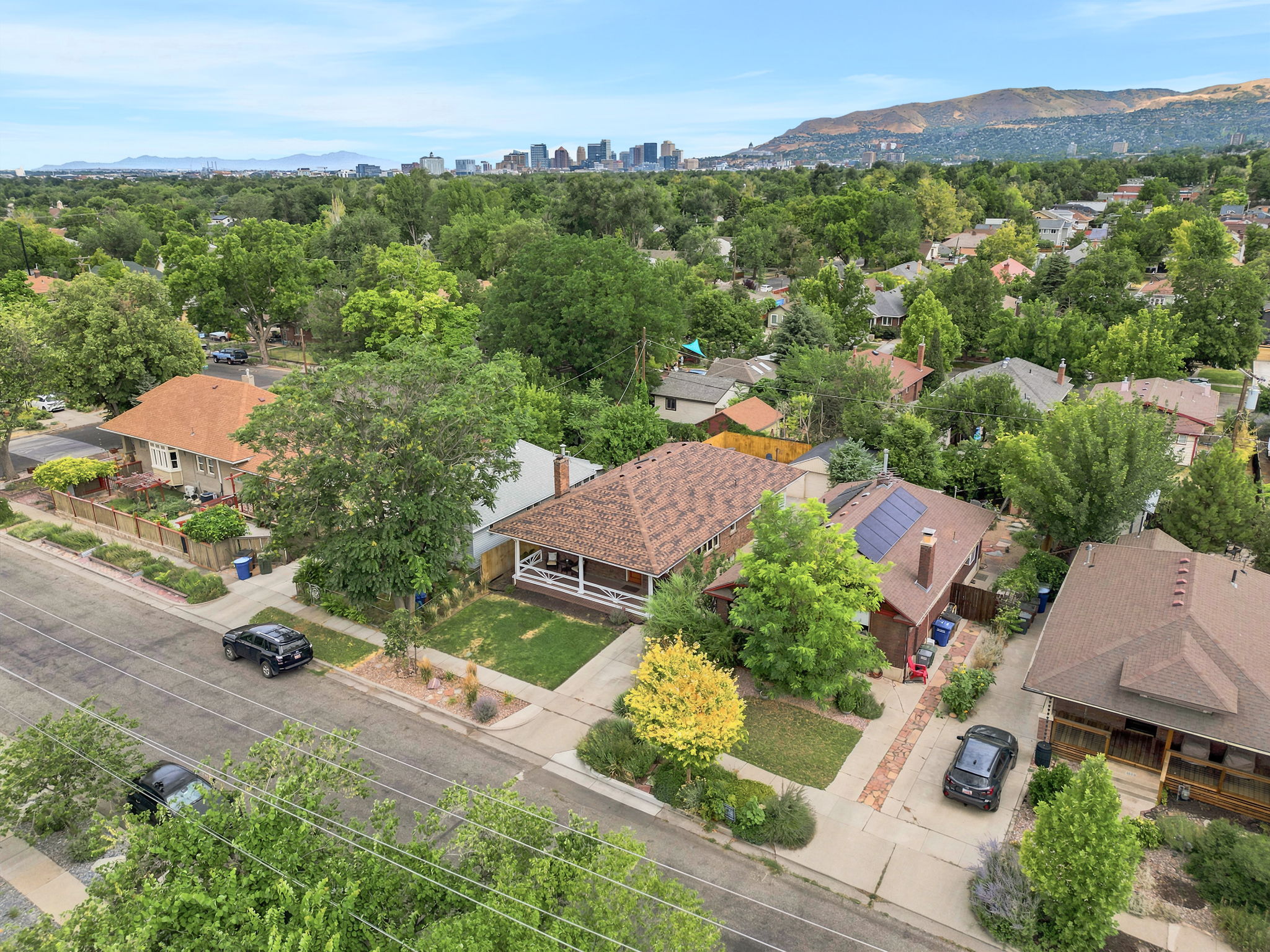 Aerial perspective showcasing a residential neighborhood with a distant urban skyline and mountain backdrop
