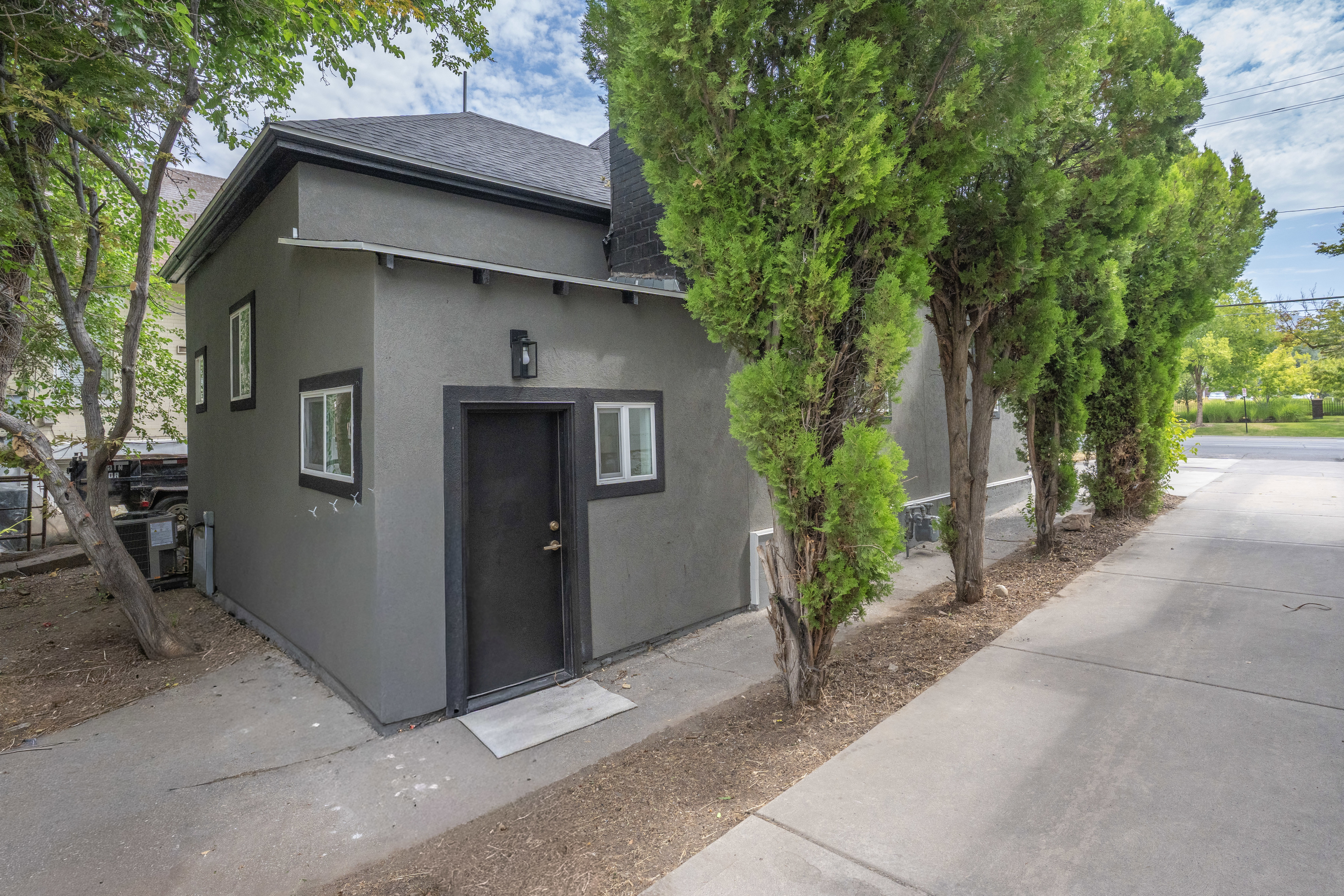Contemporary exterior with dark gray stucco siding and contrasting black trim