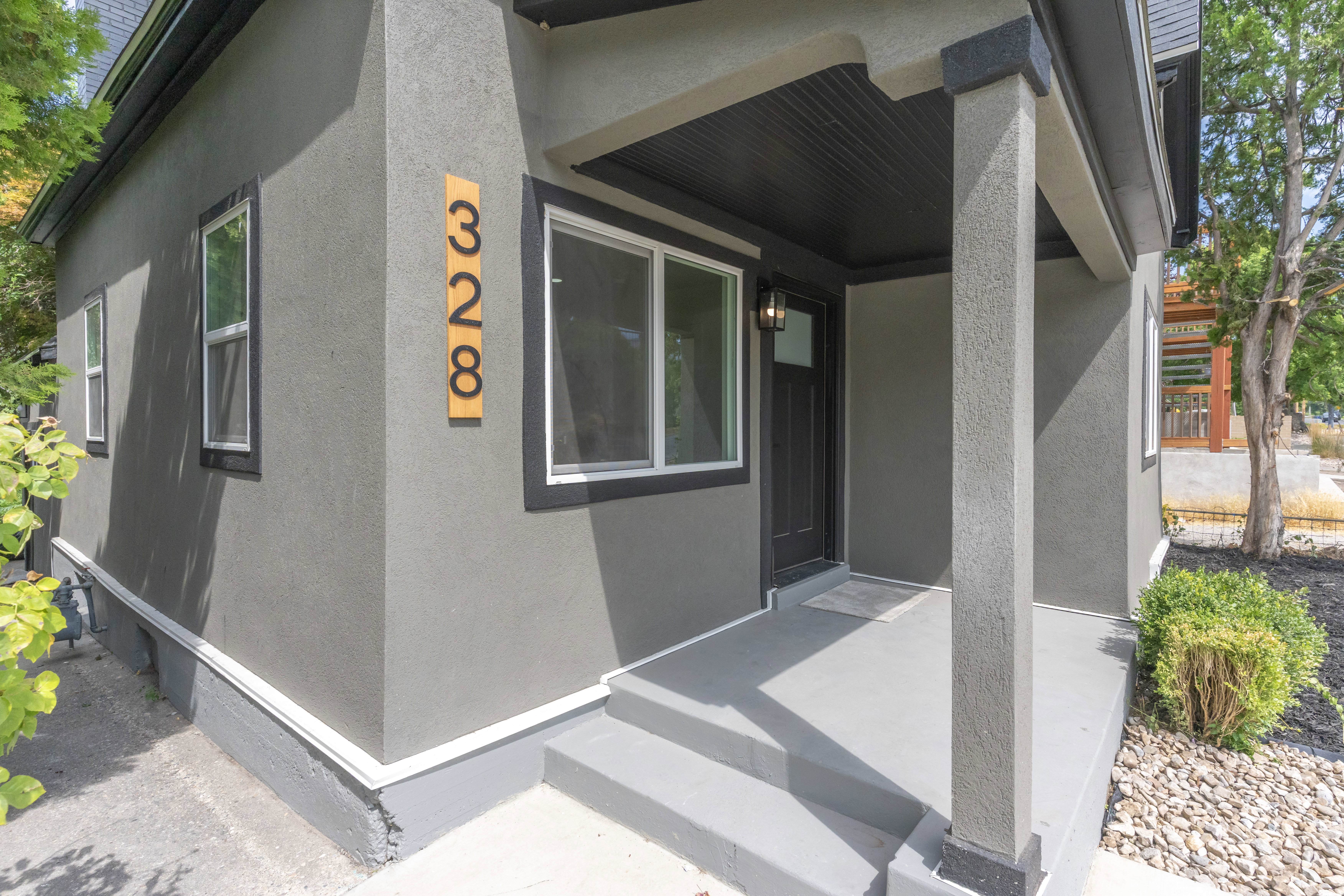 Contemporary exterior with dark gray stucco finish and contrasting white trim