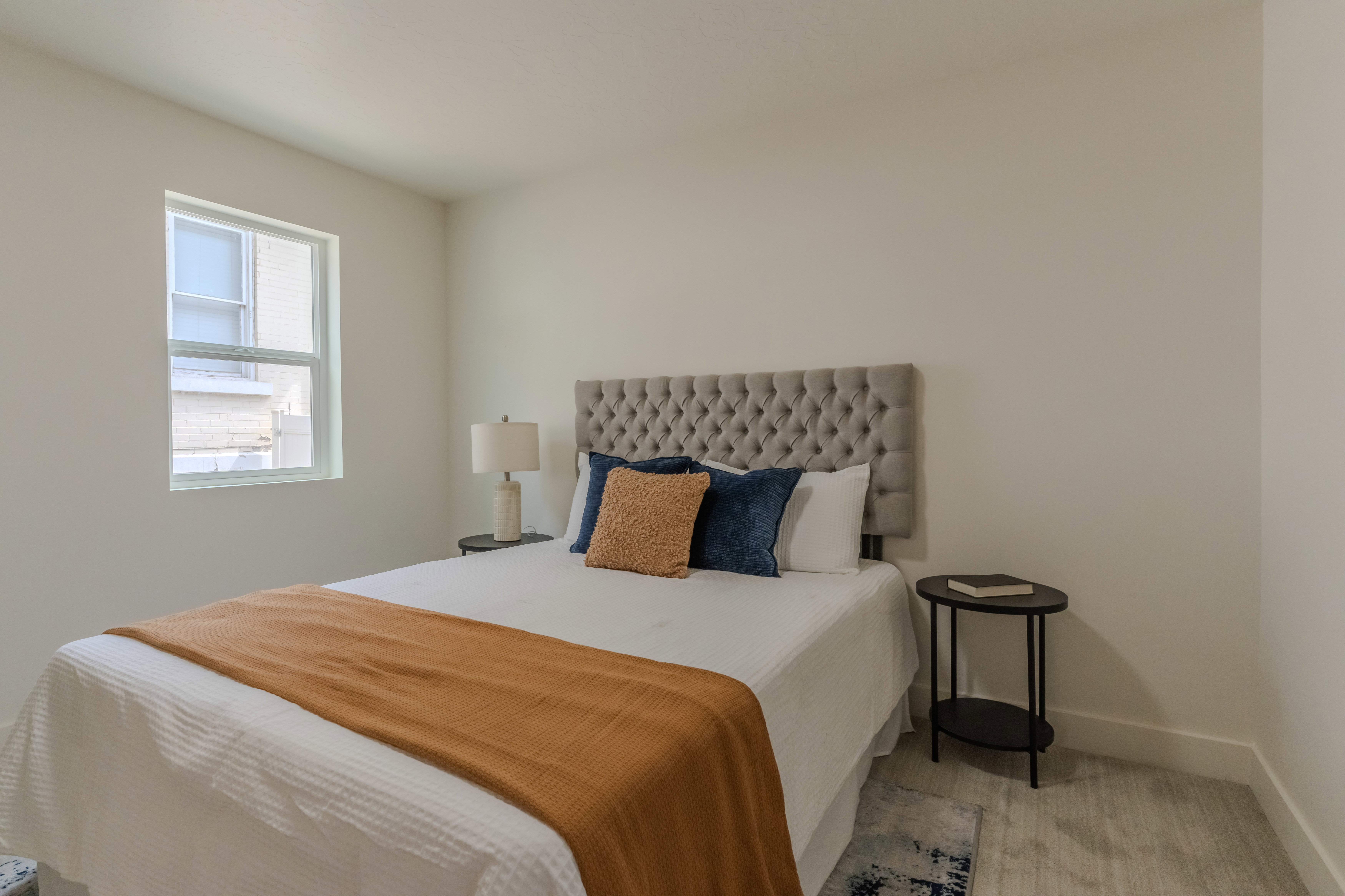 Windowed room featuring light-toned walls and wood-finish flooring