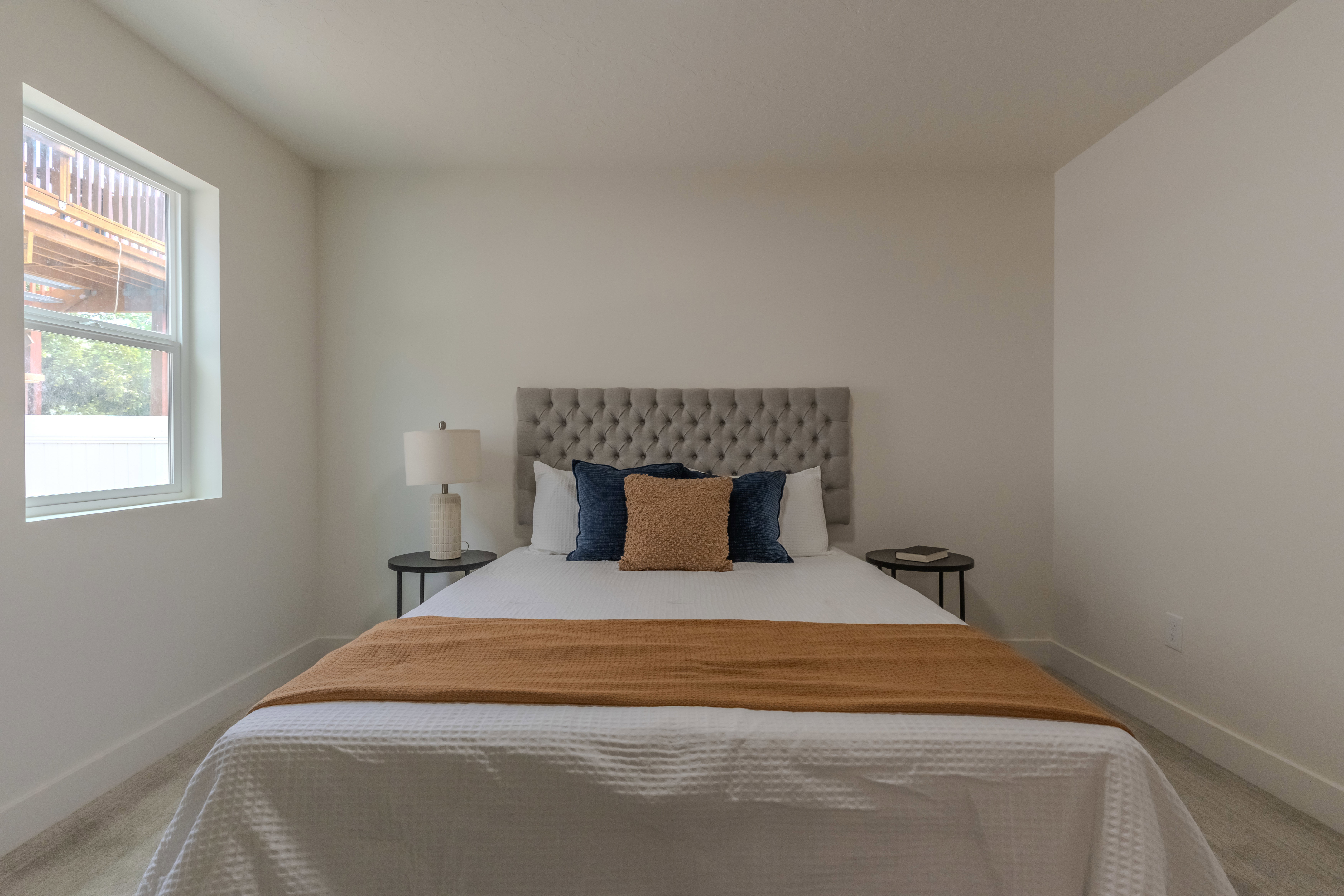 Well-lit interior space featuring neutral wall tones, a modern window with white trim, and light-colored flooring