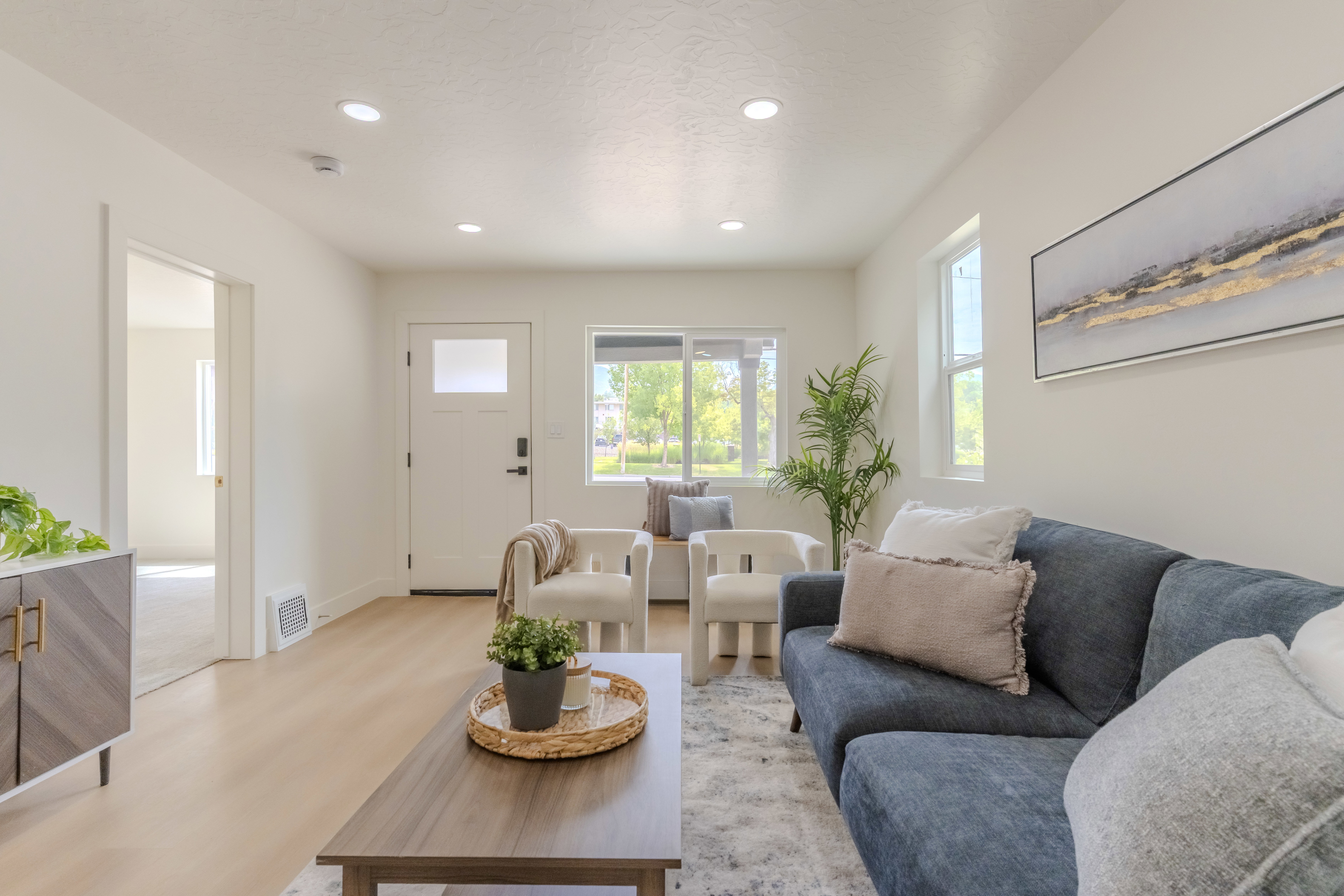 Living area with light wood-finish flooring, recessed lighting, and white walls