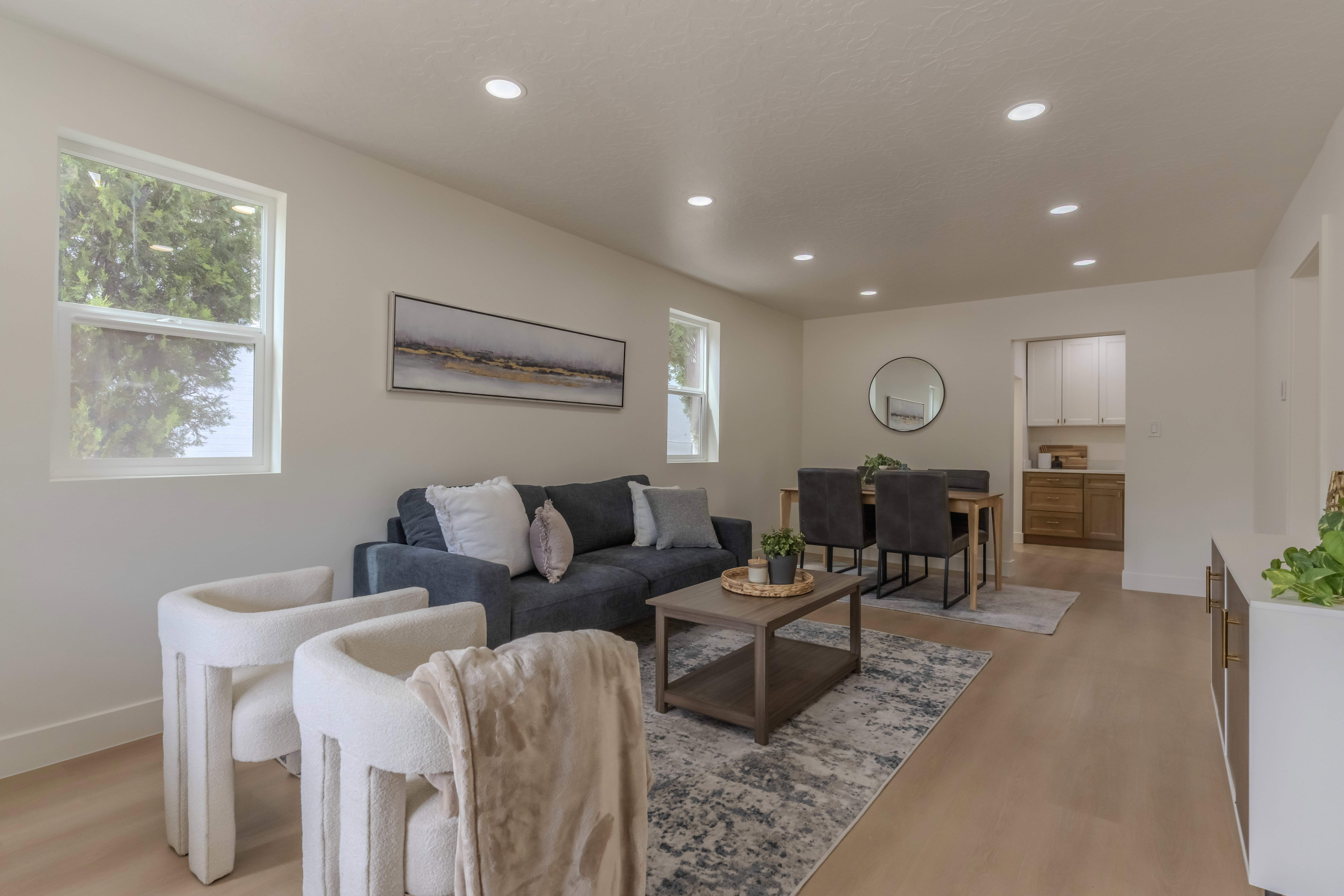 Open-concept living and dining area featuring recessed lighting, light wood-finish flooring, and multiple windows providing natural light