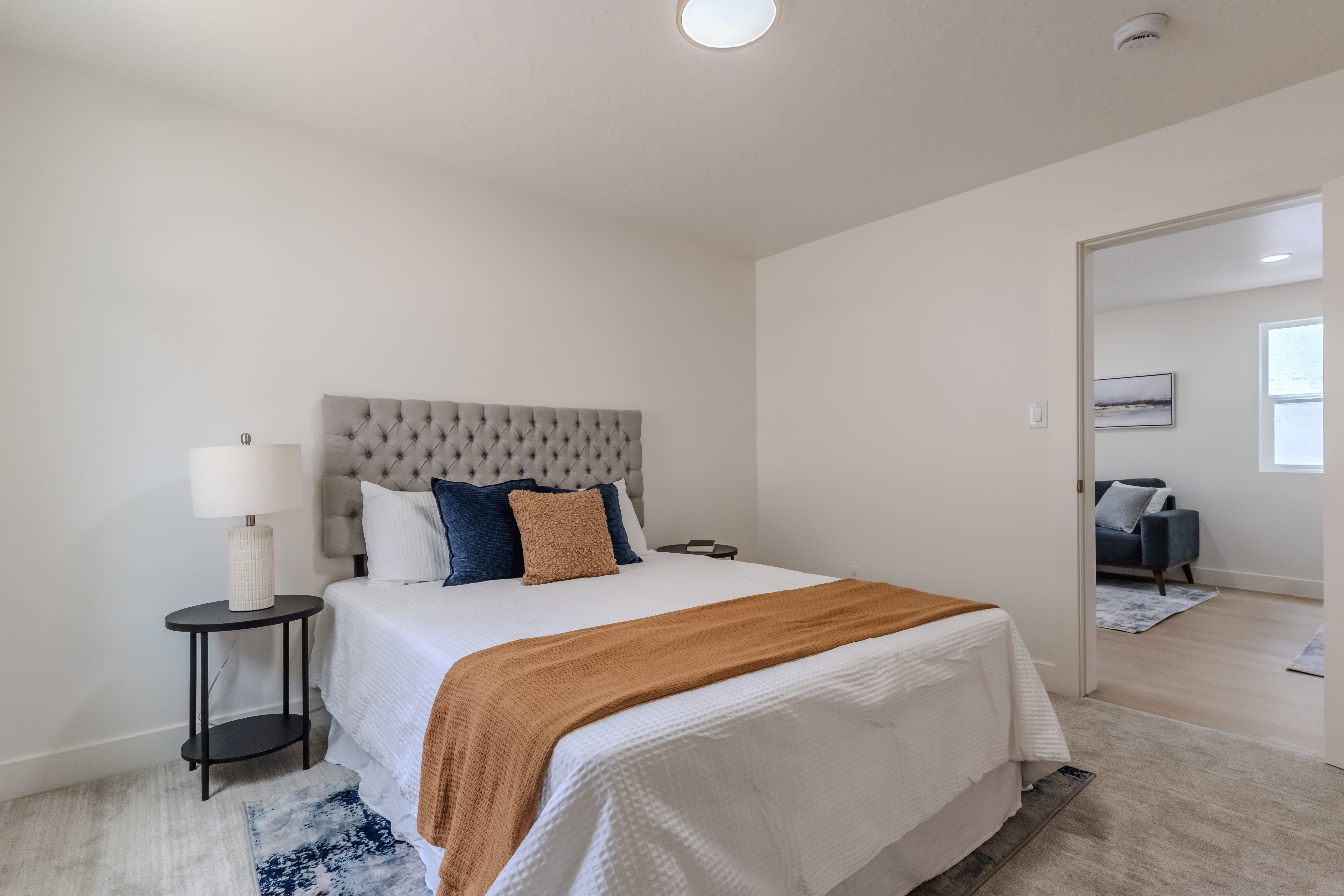 Bedroom featuring a tufted headboard, light-toned wall paint, and recessed lighting