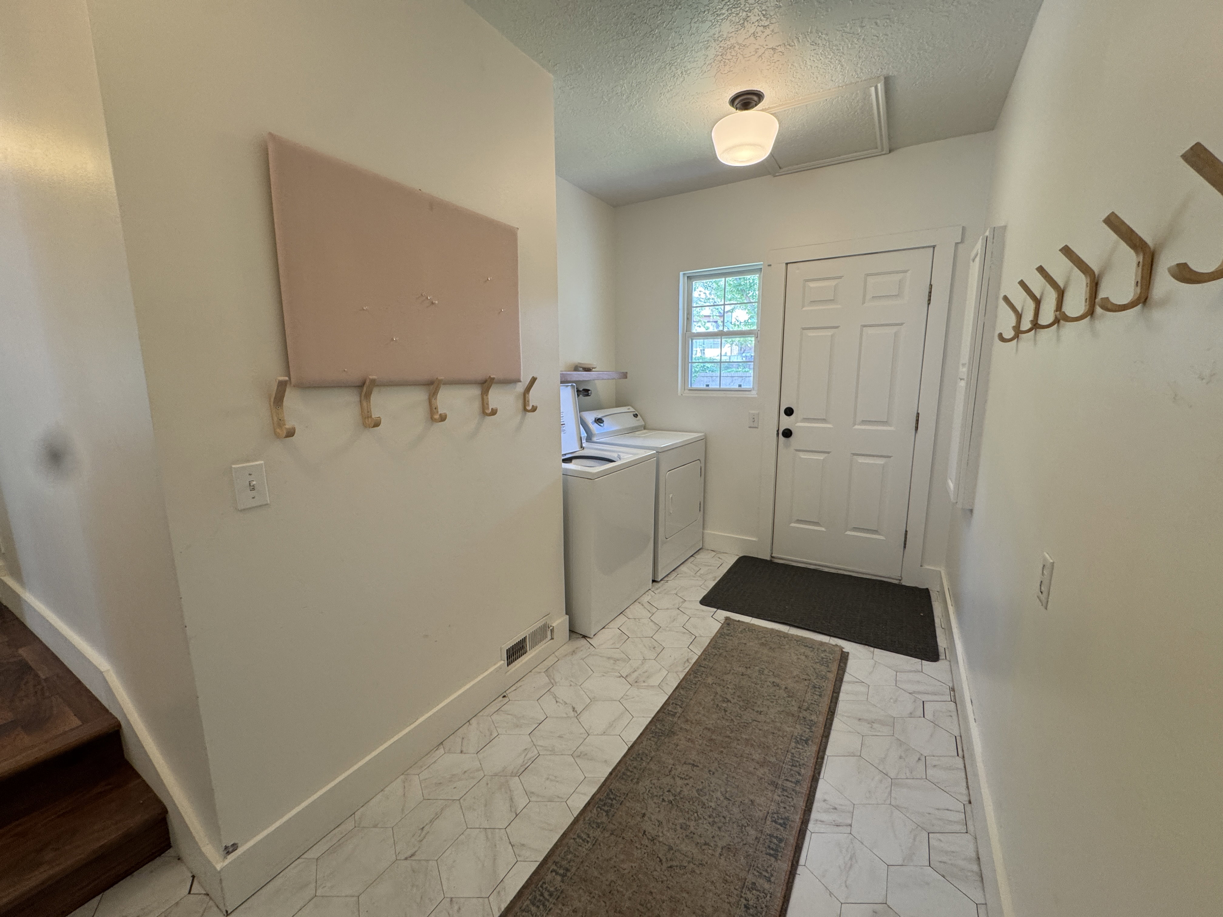 Entryway featuring hexagonal floor tiling, a paneled door with hardware, a window, and a ceiling-mounted light fixture