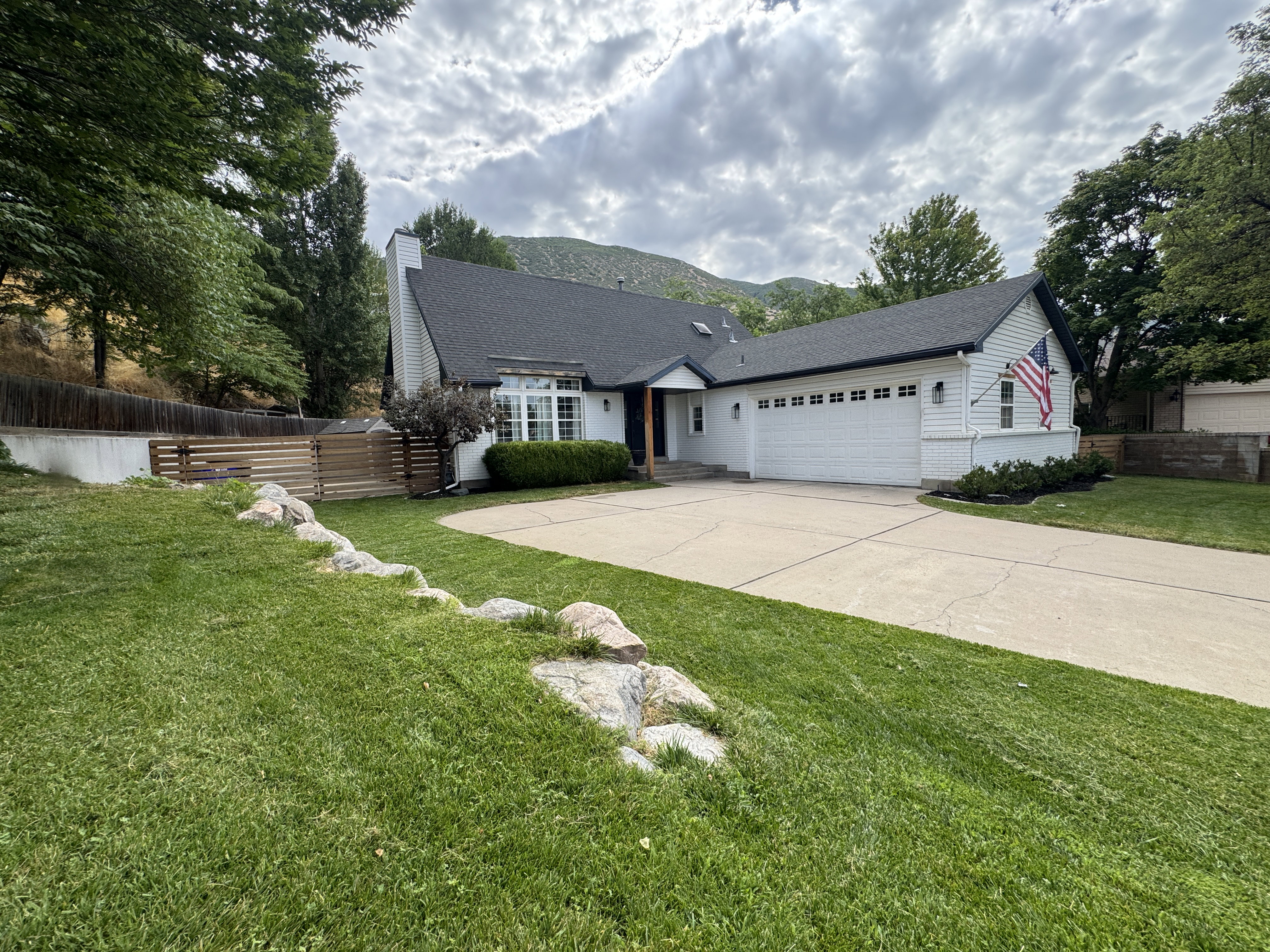 White exterior with black roofline accents, featuring a two-car garage with multiple windows