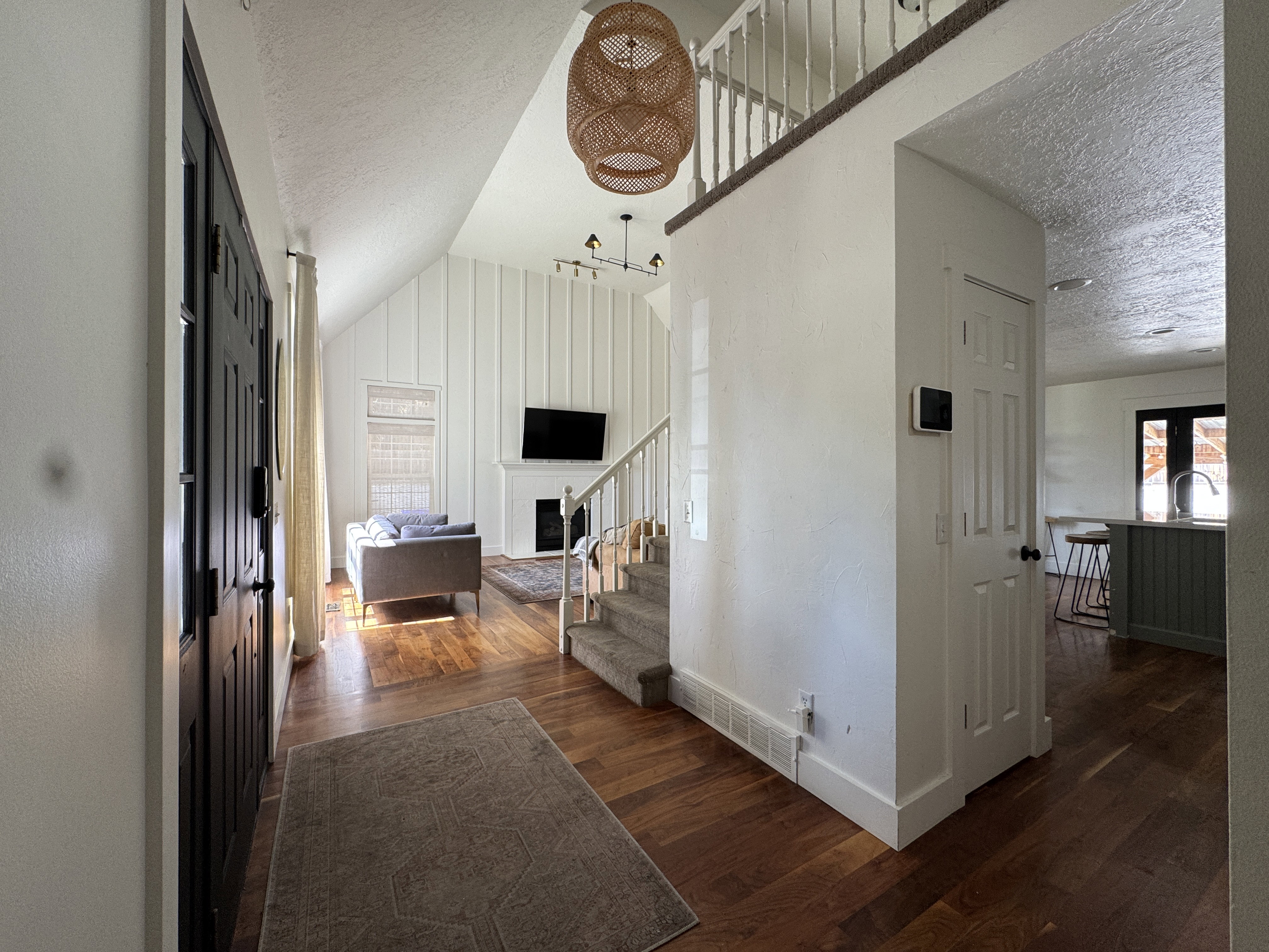 Vaulted ceilings highlight the living area, featuring wood-finish flooring and vertical shiplap paneling
