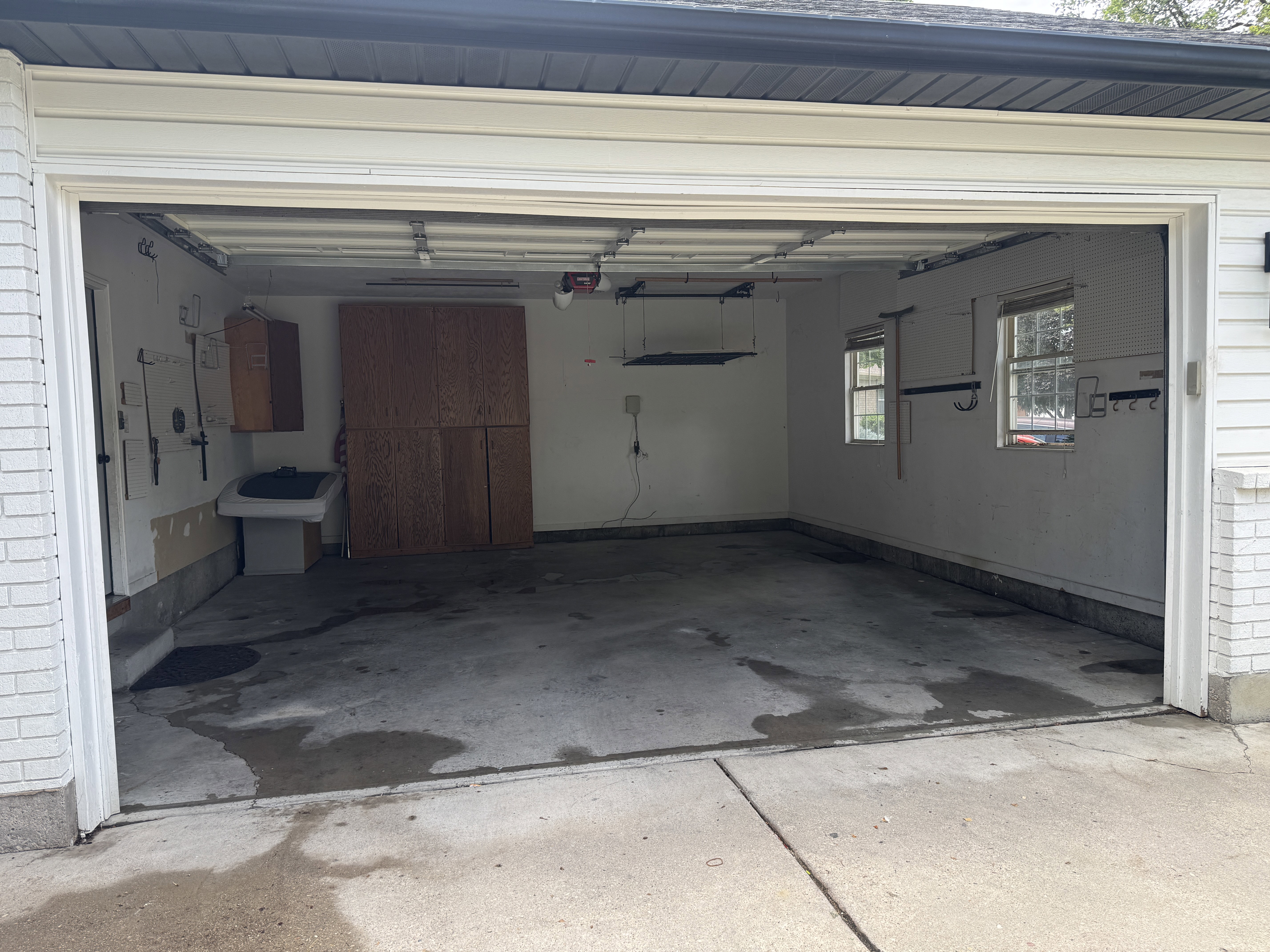 Spacious garage featuring concrete flooring and two windows providing natural light